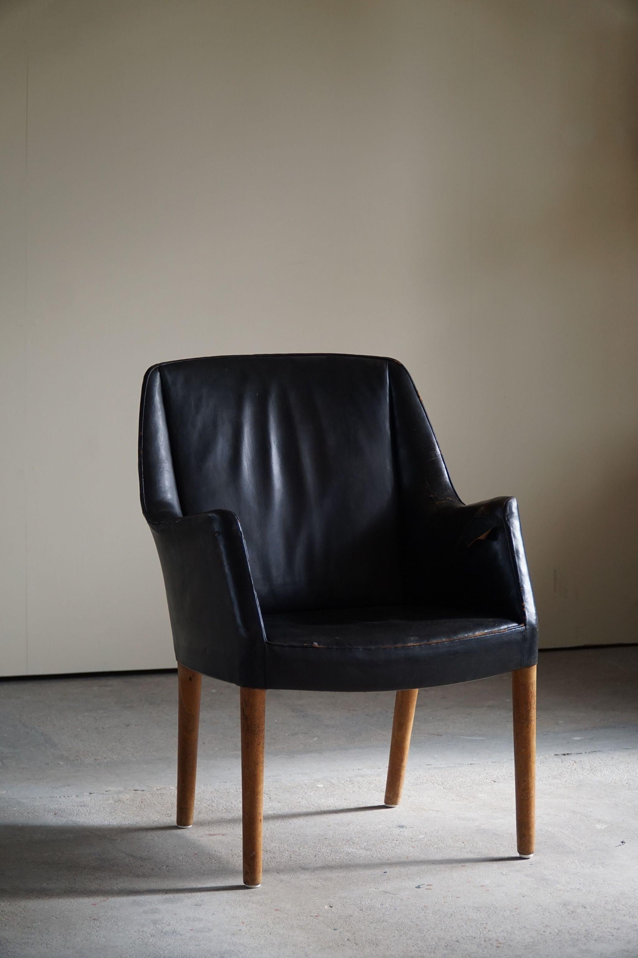 Rare fauteuil en chêne et cuir noir joliment patiné. Conçu par Nanna Ditzel pour le tribunal du comté de Copenhague. Cet exemple n'est fabriqué qu'en quelques exemplaires et constitue donc une pièce de collection rare. 

Documenté par une maison