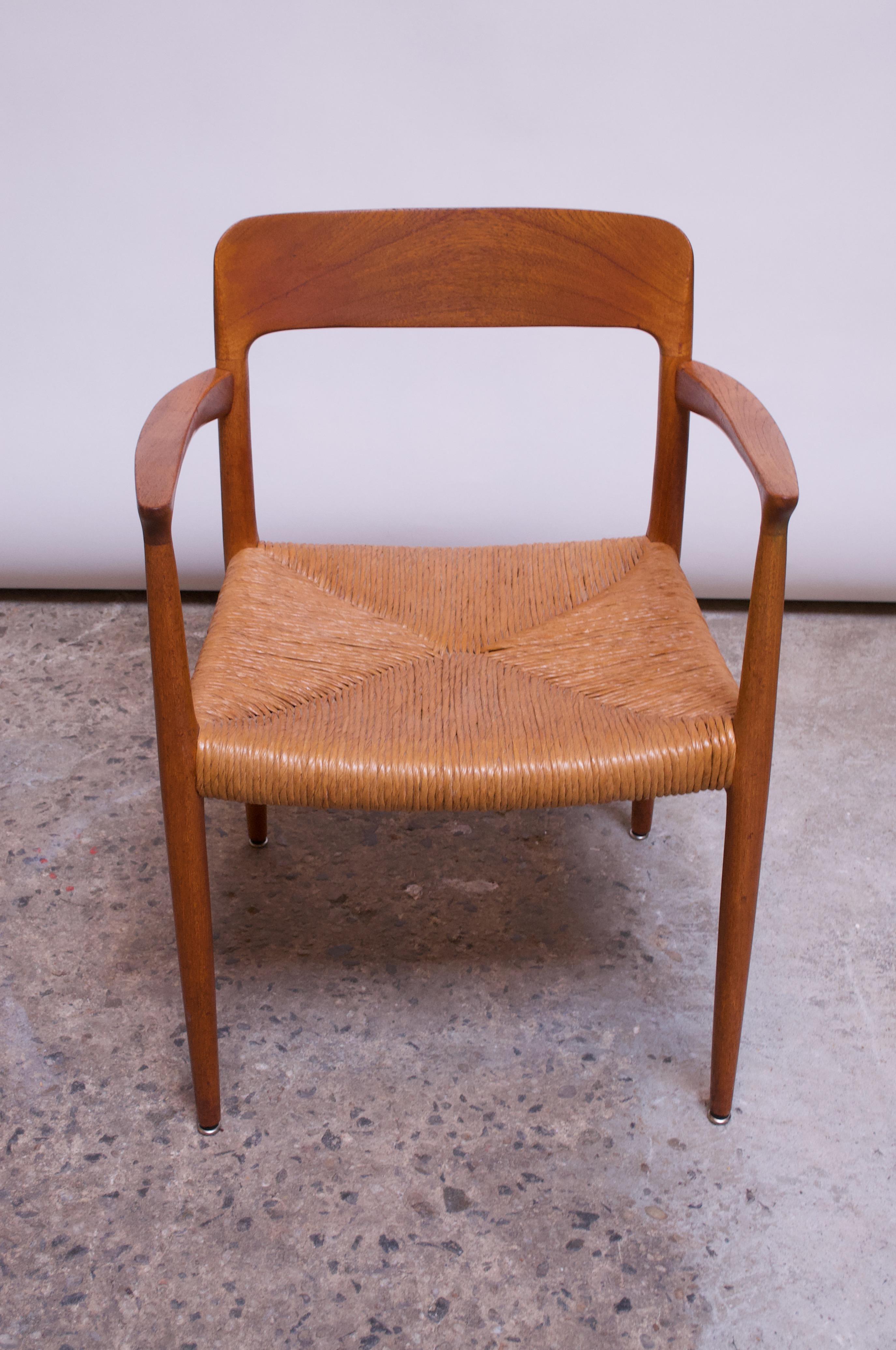 Model 56 oak dining chair / desk chair with sculpted arm rests designed in the 1950s by Niels Otto Møller for J.L. Møller. 
Conservatively refinished condition, retaining its original woven paper cord seat. 
Seat is intact; few scuffs remain to