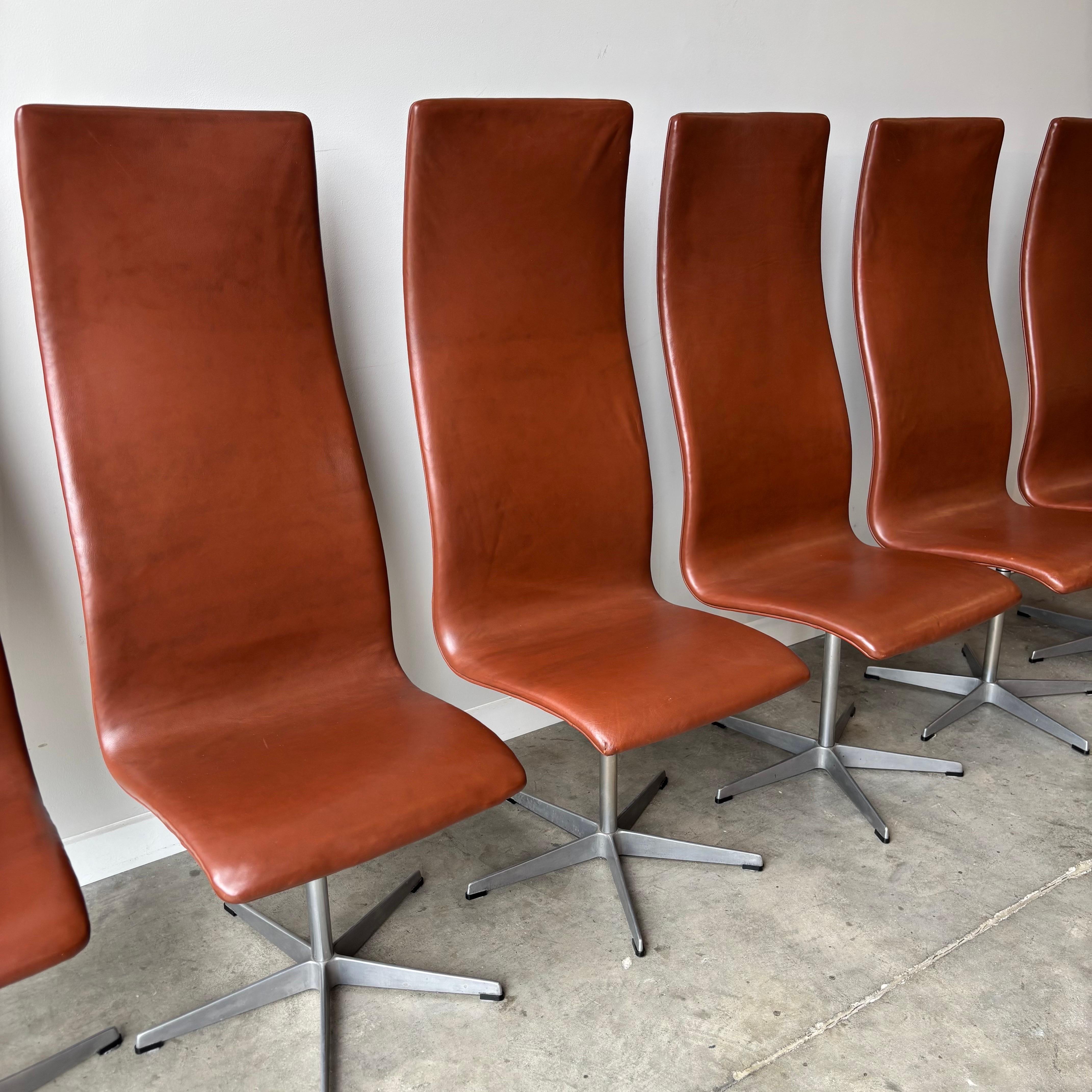 This collection consists of six Oxford dining chairs, created by Danish designer Arne Jacobsen for Fritz Hansen. The chairs showcase Jacobsen's signature mid-century aesthetic with their elevated backrest design and distinctive five-point metal