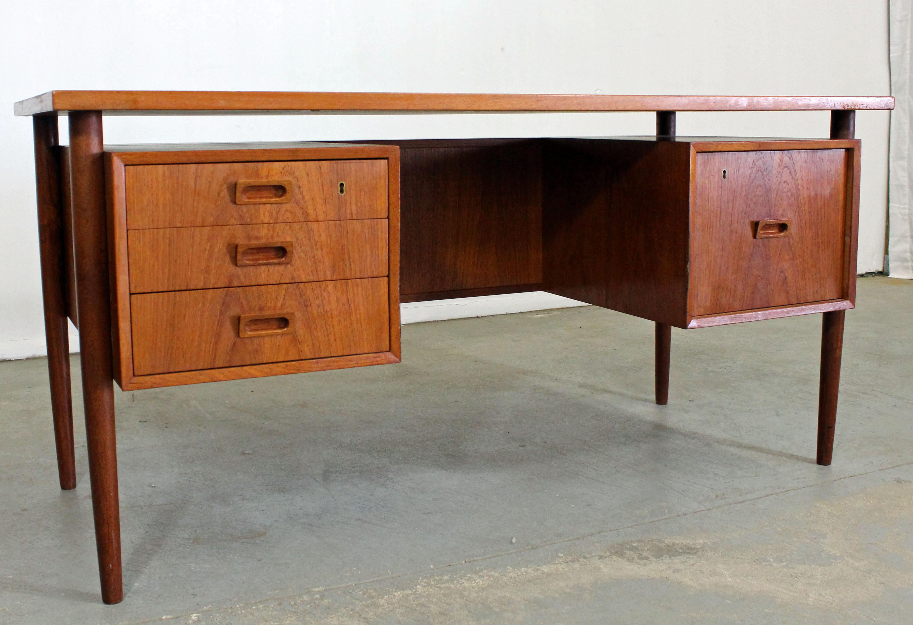 Midcentury Danish Modern Arne Vodder Style Bornholm floating top teak desk

Offered is a super cool Danish Modern desk with a floating top and full front shelf. It has three drawers on the left and a file cabinet on the right. The desk is in good