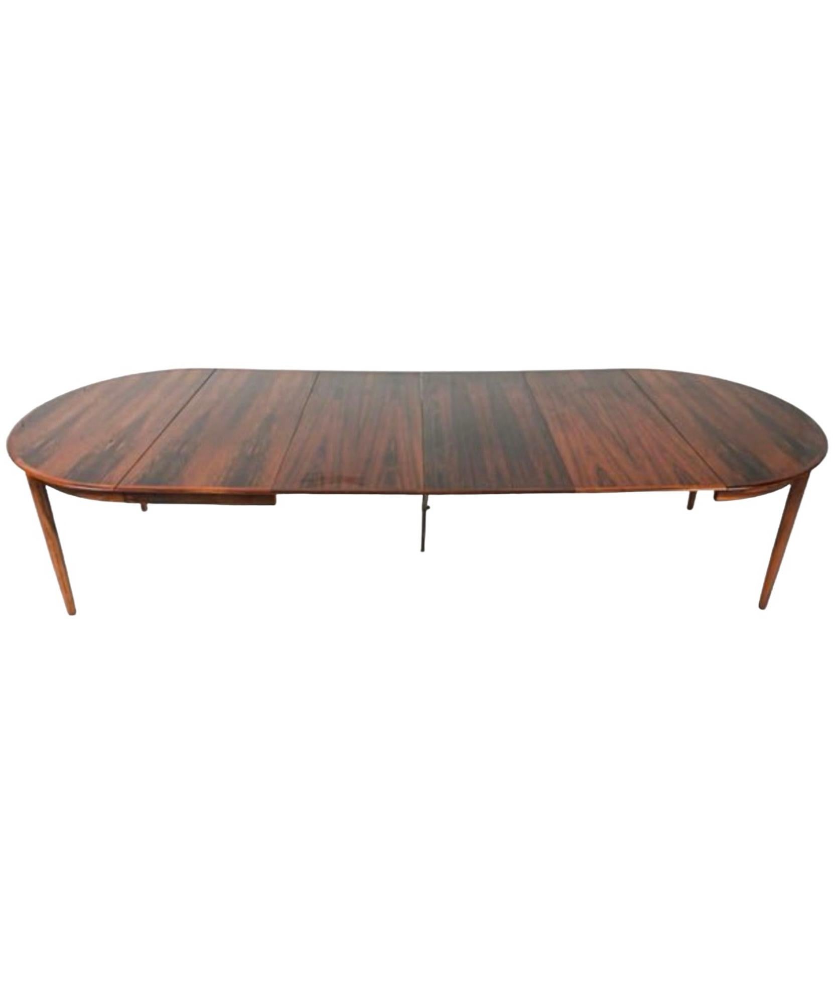 This is a round Danish modern round rosewood dining table in the manner of Arne Vodder. The table has 4 twenty inch leaves, which is highly unusual. It is marked with the Denmark stamp. It is in very good condition.

My shipping is for the