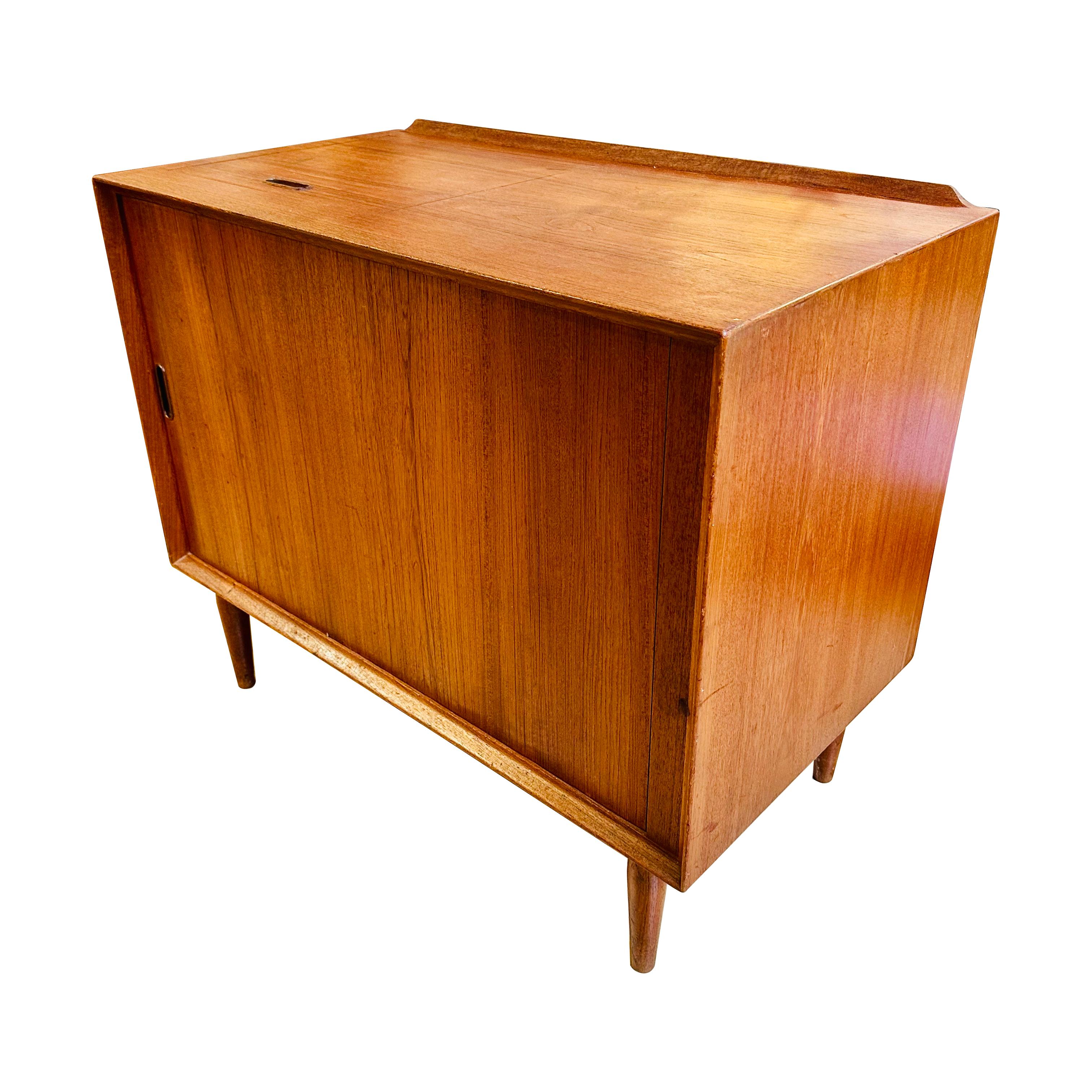 Danish Modern teak hi-fi cabinet by Arne Vodder for Sibast. This piece features a distinctive tambour door that smoothly slides open to reveal ample space for audio equipment and accessories, as well as a hinged top panel for turntable access. Ideal