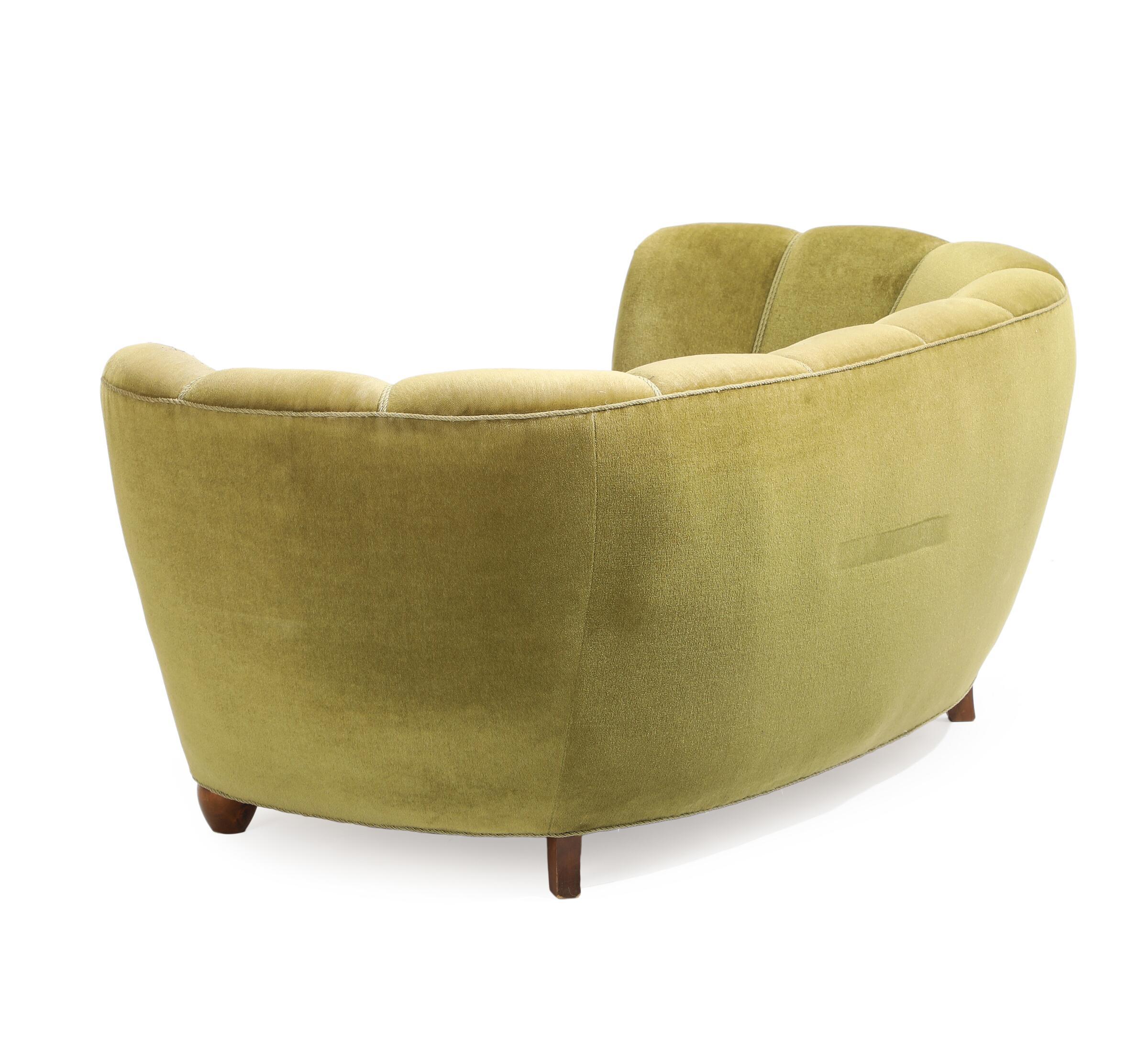 Comfortable curved sofa with channelled back, nicknamed 'banana' sofa, from Denmark, 1930's 
with decorative frieze along the base. In light green velour.