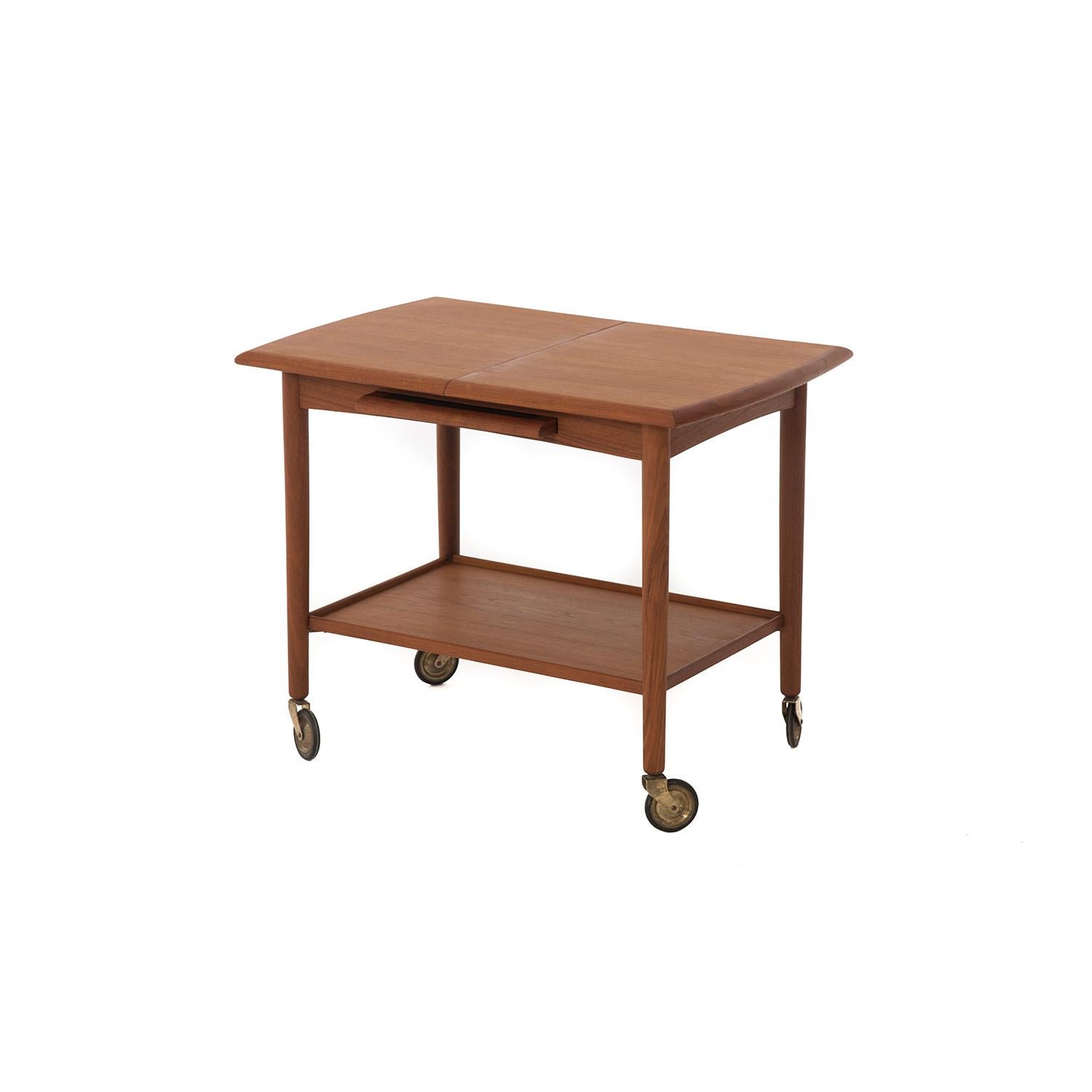 Expanding teak bar cart on wheels with built in storage for black laminate leaf, which can also be used as a serving tray or coaster.