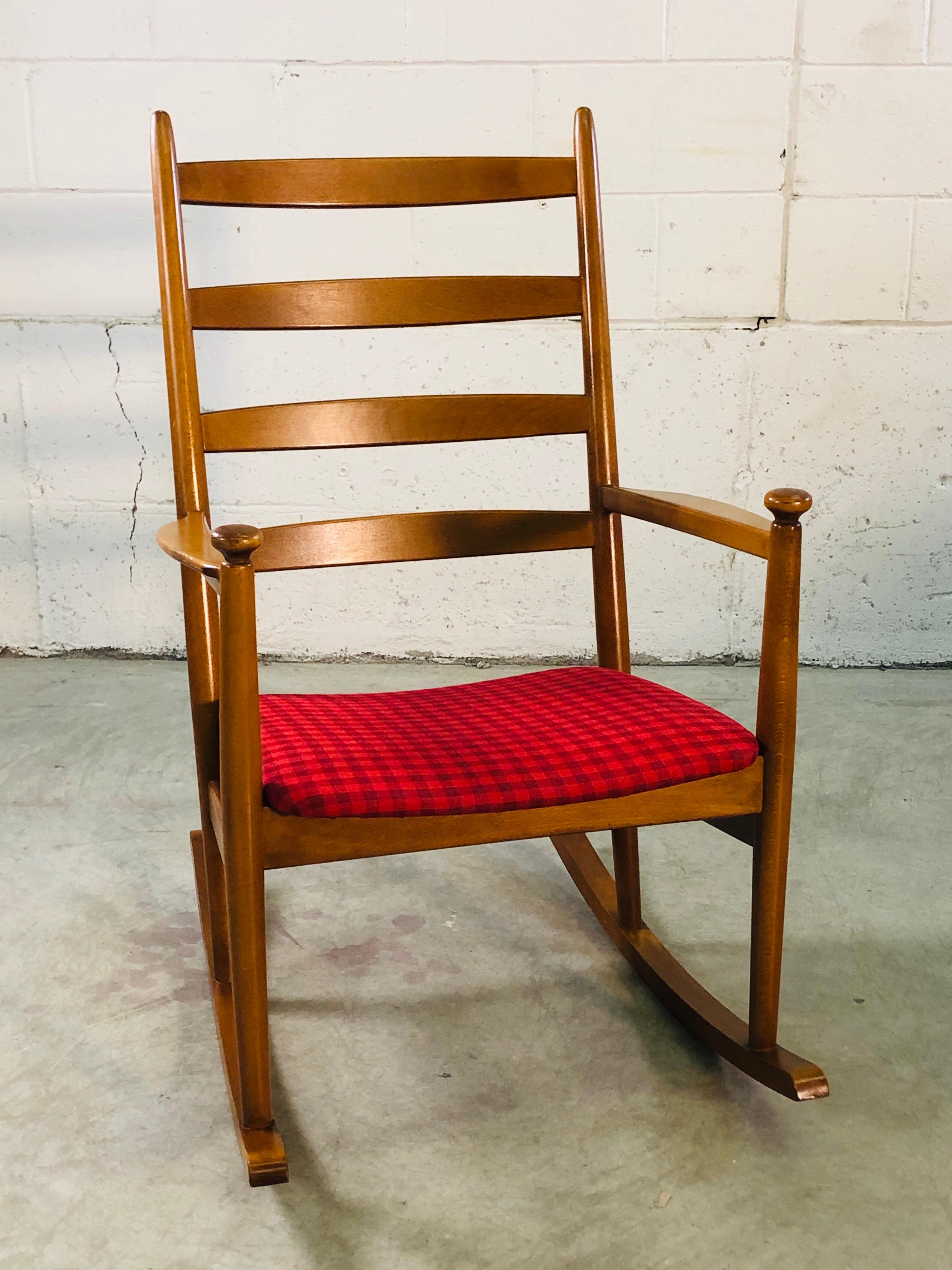 Vintage Danish modern beechwood rocking chair with gigham fabric designed by Niels Eilersen. The rocking chair is very comfortable and well designed with a curved ladder back. No marks.