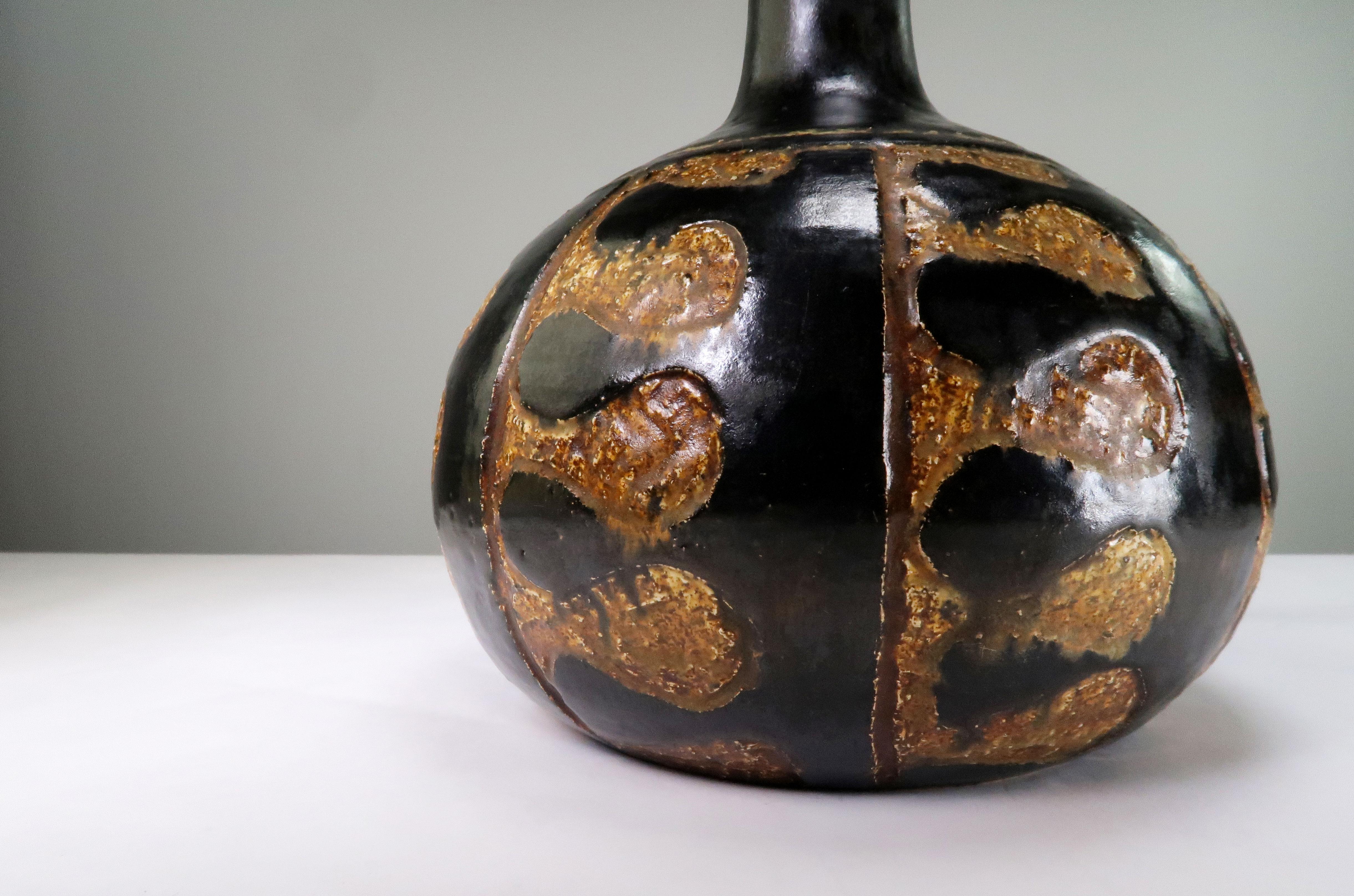 Rustic and stunning Danish Mid-Century Modern handmade and hand decorated ceramic table lamp. By Danish designer Jette Hellerøe in the early 1970s. Black glazed neck with black and spicy bronze colored organic and stylized pattern around the belly.