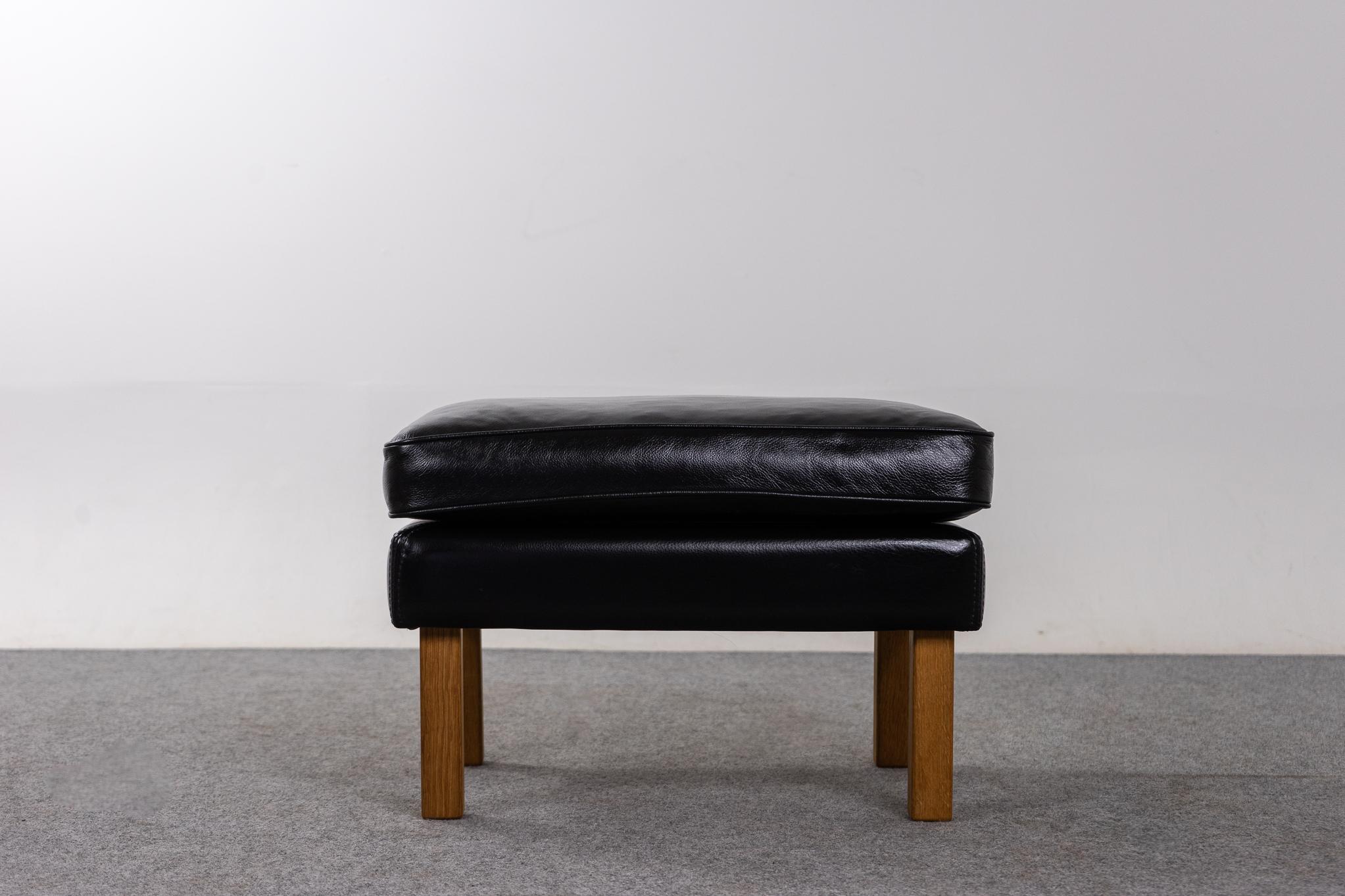 Leather Danish footstool, circa 1960's. Robust, compact design with contrasting oak legs. Leather has been cleaned and conditioned. Sturdy and structurally sound. Would make a great entryway seat!

Please inquire for international and remote