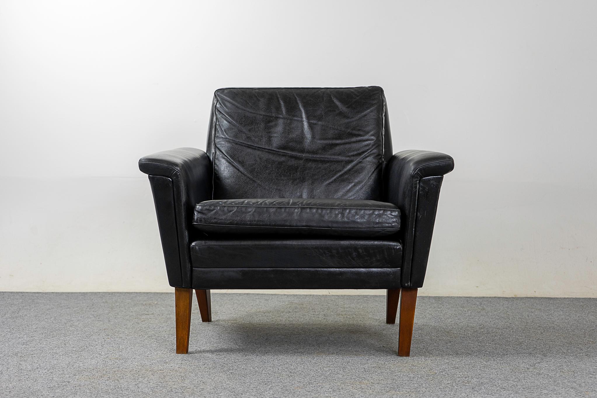 Leather midcentury lounge chair, circa 1960s. Clean lined modern lounge chair with original black leather and solid wood angled feet.