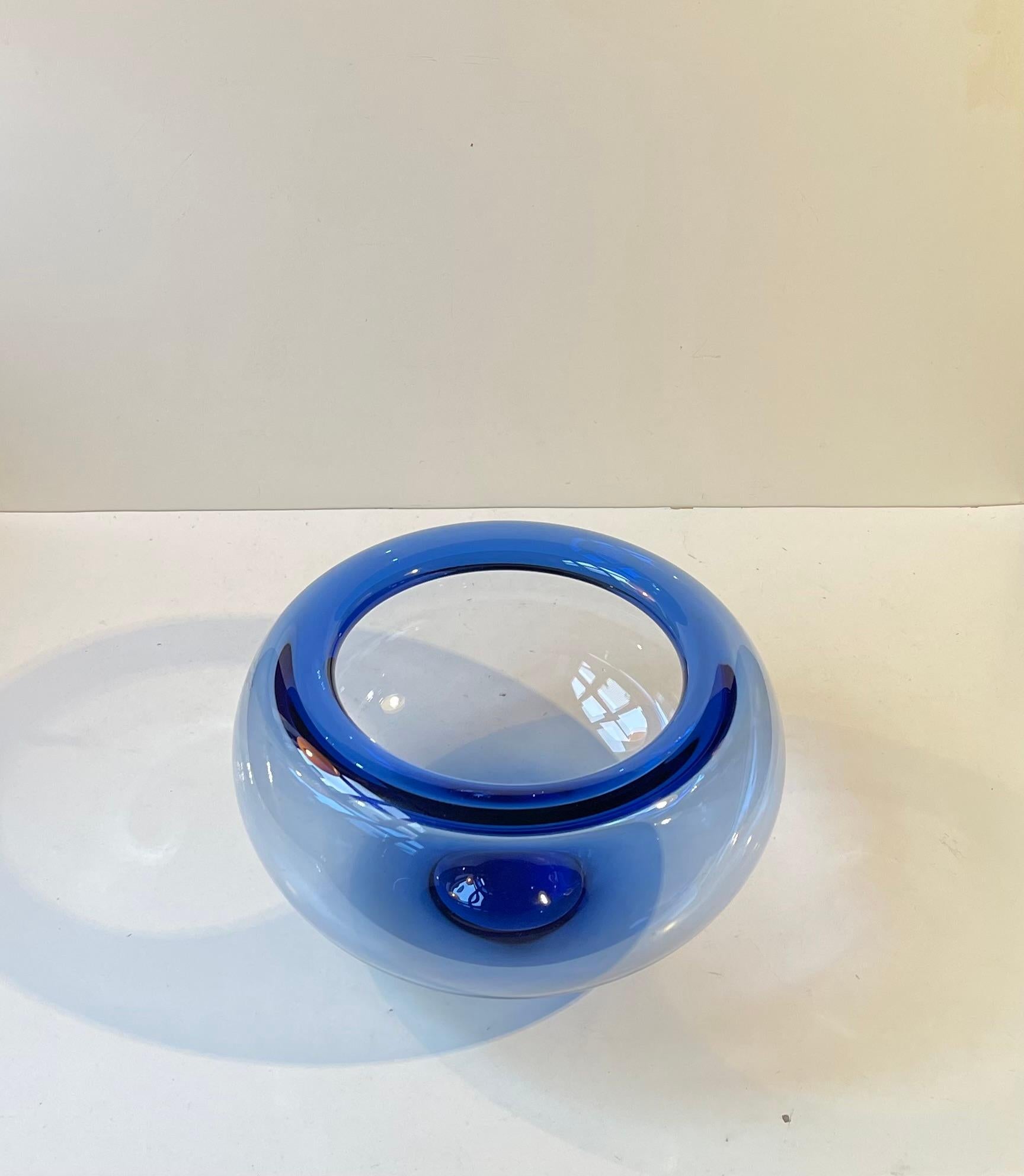 Gran cuenco soplado a mano de cristal transparente teñido de azul, diseñado por Per Lütken en 1955. Esta pieza se fabricó en Holmegaard, Dinamarca, a mediados-finales de la década de 1970. Se llama Provenza o pecera de oro. Algunas personas de