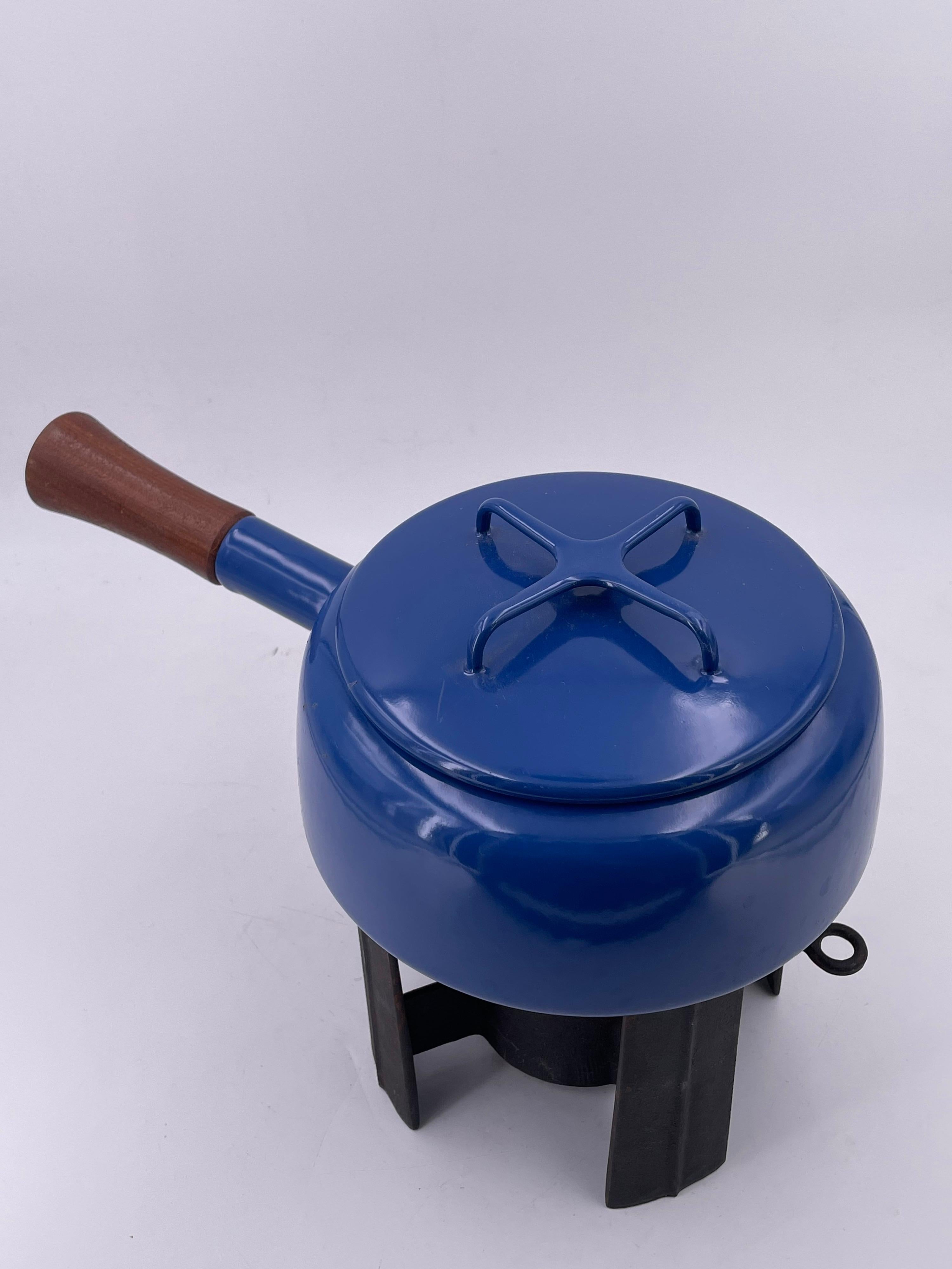 Beautiful, unique, very nice and clean, 1950s fondue pot, in red enameled finish with white interior, cast iron base and solid teak handle. Excellent condition. A small flea bite around the lid as shown, designed by Quistgaard and produced by Dansk.