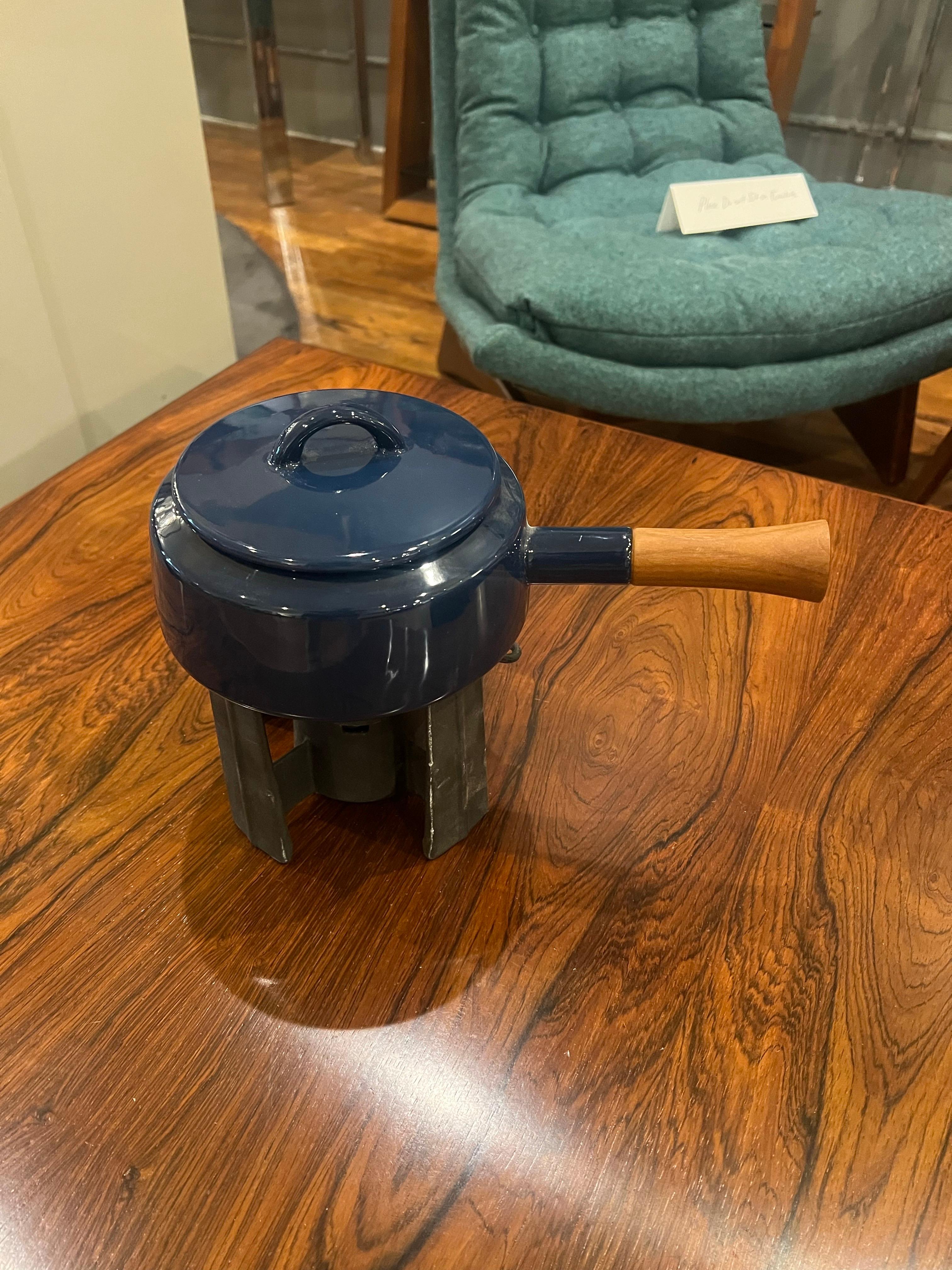 Beautiful, unique, very nice and clean, 1990s fondue pot, in navy blue enameled finish with white interior, cast iron base and solid teak handle. Excellent condition. never used comes with original booklet