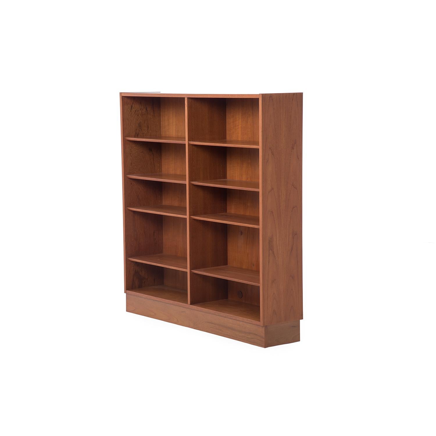 This plinth based teak bookcase features adjustable shelves in two columns. Reverse beveled shelves are adjustable, and the oil finished teak wood glows warmly like only aged and properly patinated teak can.