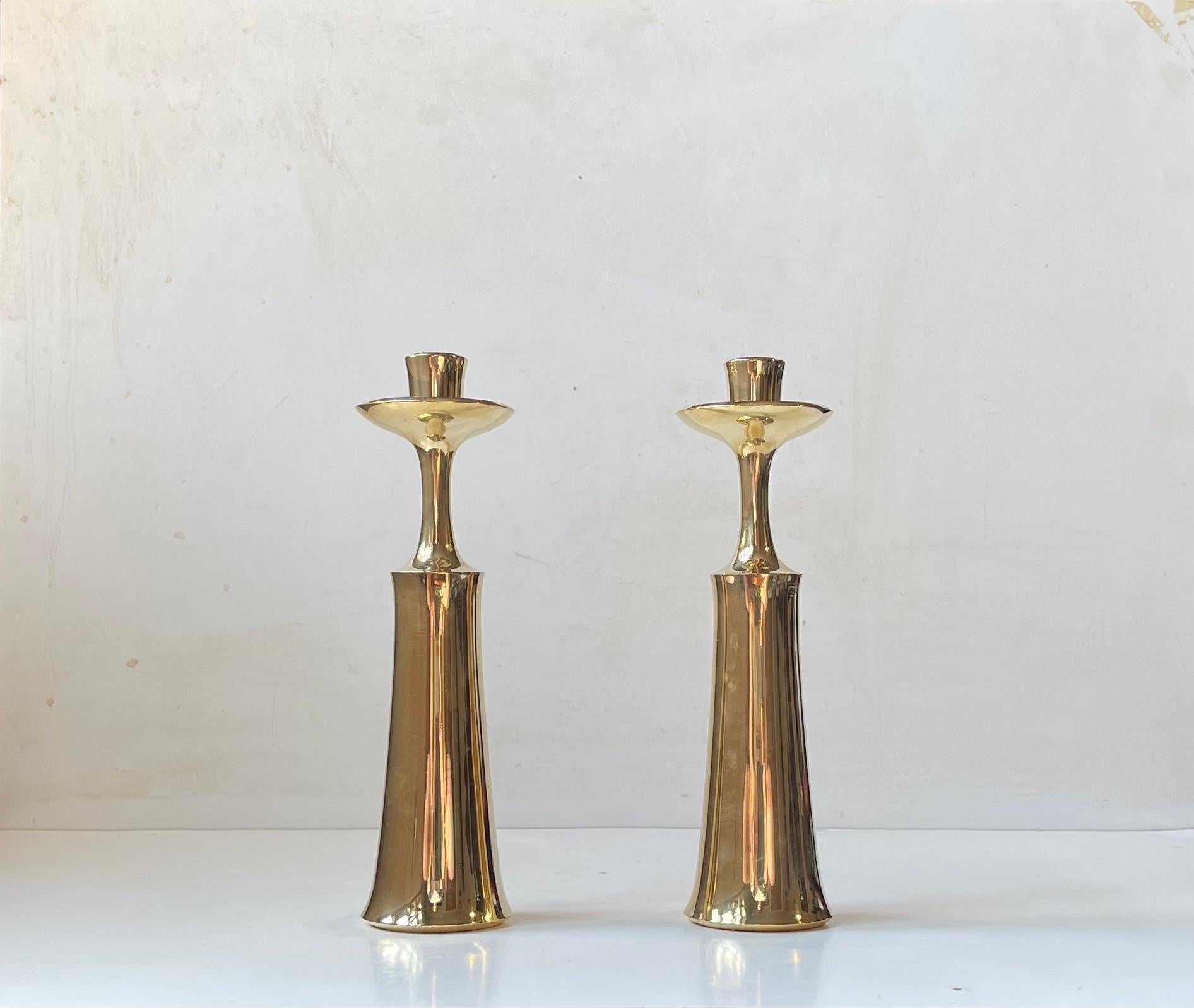 Una coppia di grandi candelieri in ottone massiccio tornito a macchina. Progettata alla fine degli anni '50 dall'icona del design industriale danese Jens Harald Quistgaard (IHQ). Sono da utilizzare con candele di dimensioni normali. Entrambi sono