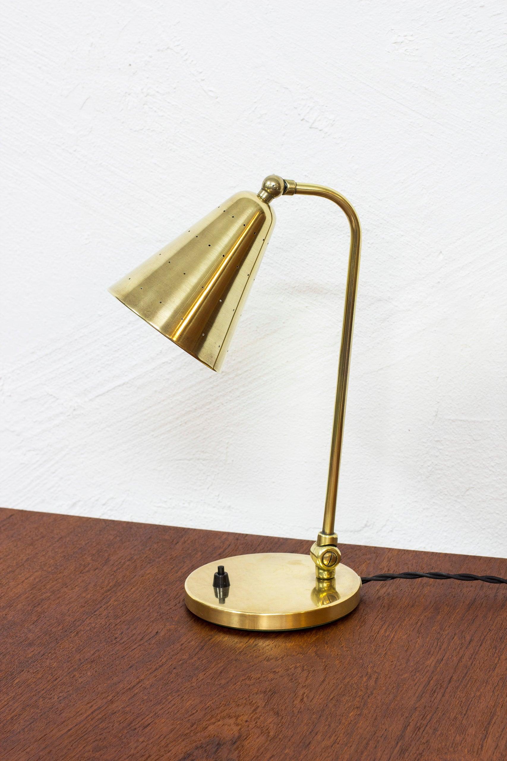 Danish modern table lamp designed by Svend Aage Holm Sørensen. Produced by his own company Holm Sørensen & Co in Denmark during the 1950s. Made entirely from solid brass. conical brass shade with white lacquered inside and perforated shade that