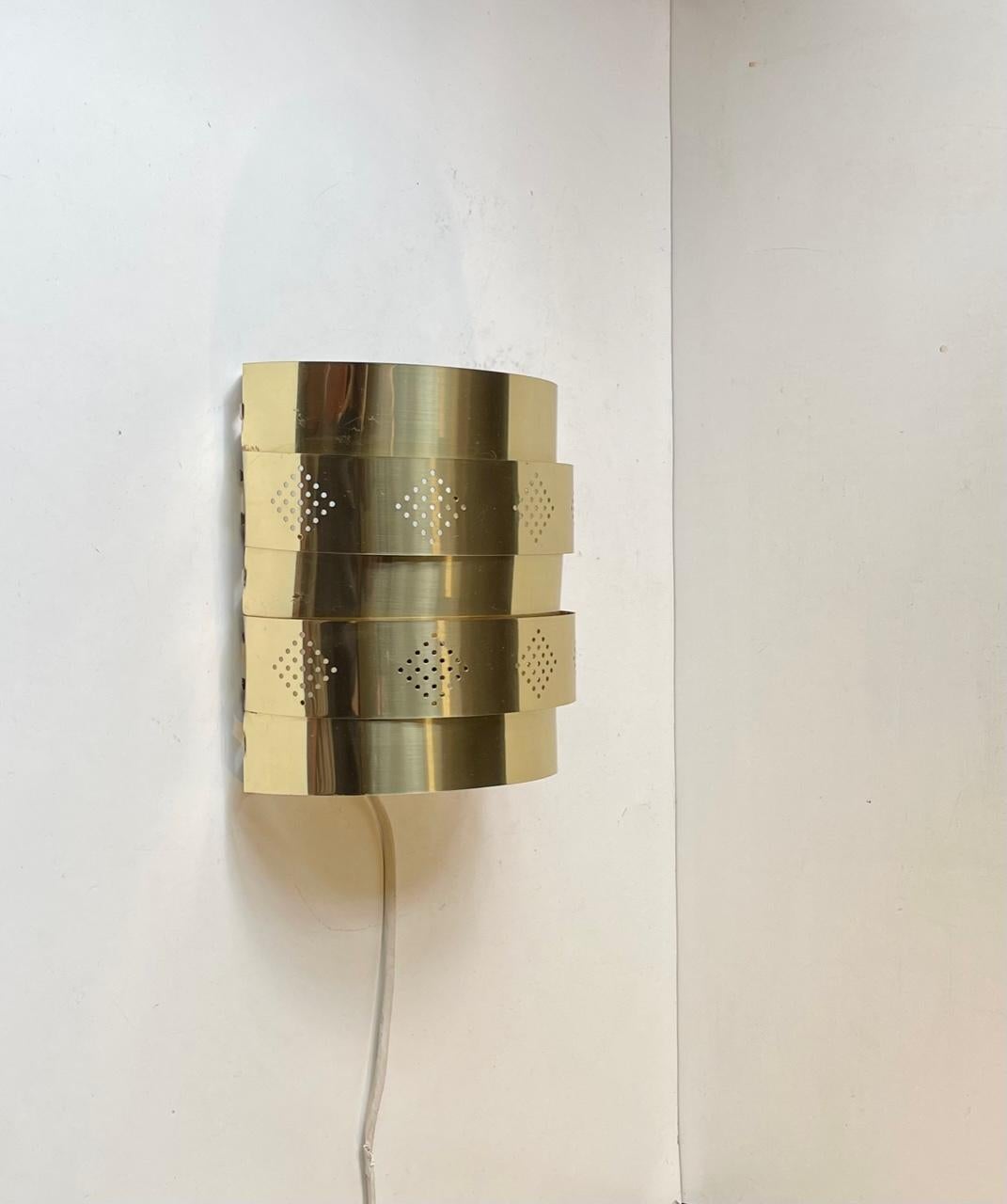 Sculptural Wall lamp designed by Werner Schou and manufactured by Coronell Elektro in Denmark during the early 1970s. Its front is made from Brass, partially perforated in Diamond shapes. This style of lighting is reminiscent of Hans Agne Jakobsson