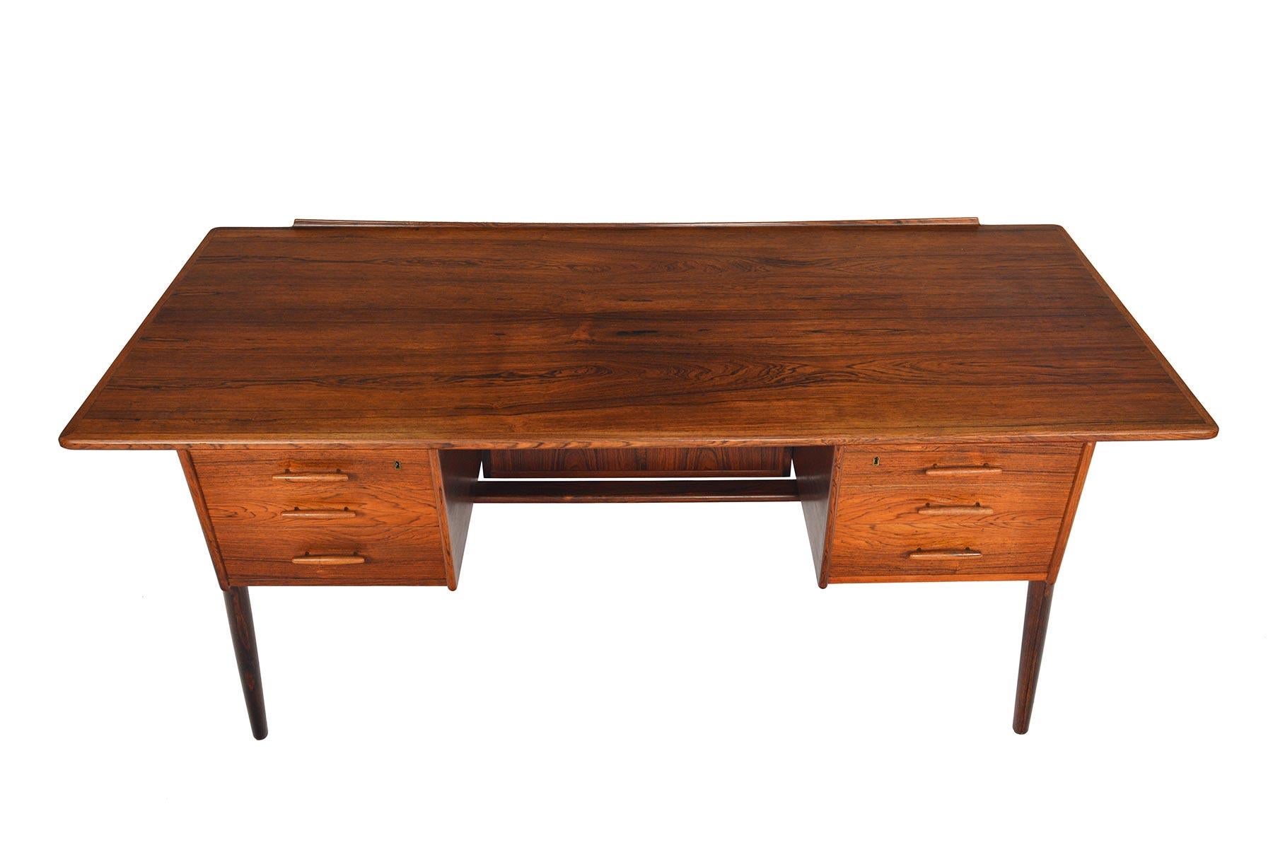 This original Danish modern executive desk crafted in Brazilian rosewood is outfitted with all the bells and whistles of show-stopping midcentury desk. Every element of this piece features unique considerations and expert craftsmanship. Sculpted