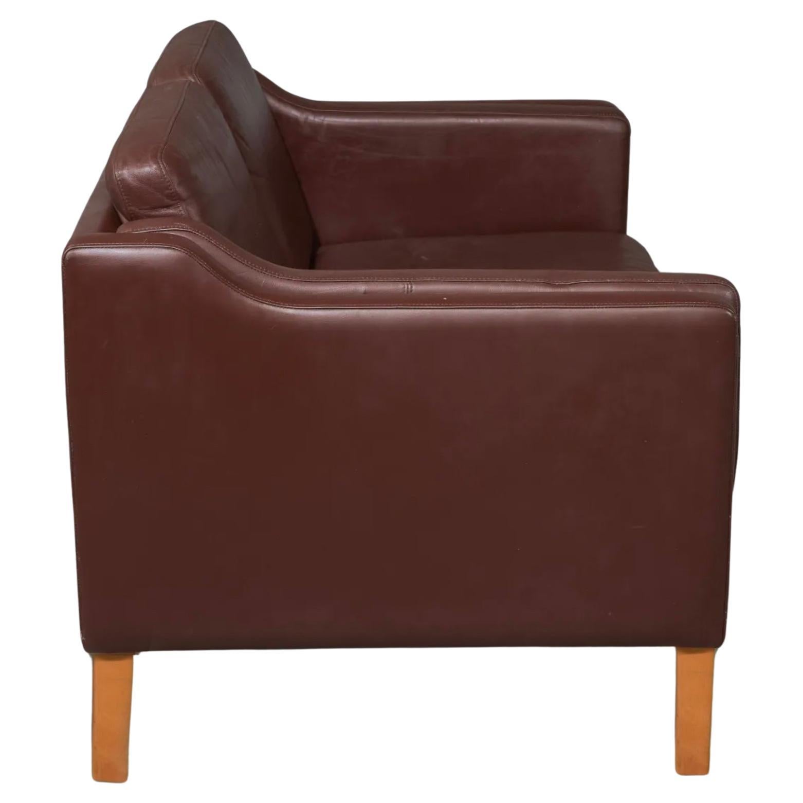 Scandinavian Danish Modern Brown Leather Two Seater Sofa or Loveseat in the style of Borge Mogensen. Soft Dark brown leather sofa on solid Birch legs. Great design. Made In Denmark Located in Brooklyn NYC.

Measures 52” w x 31” d x 30” high
Seat