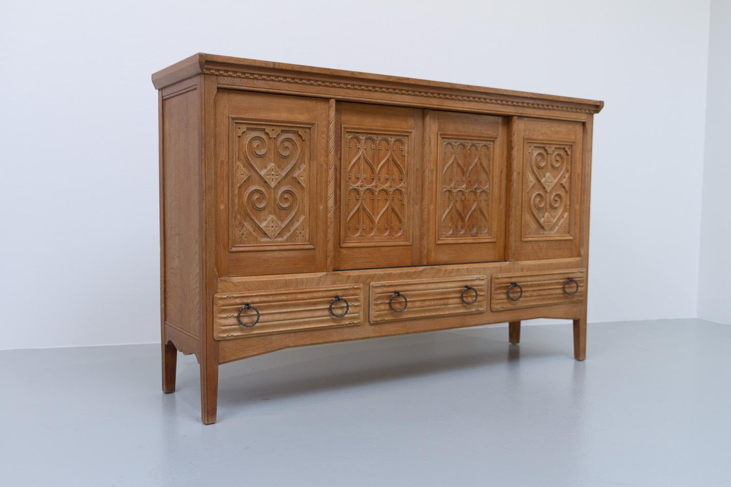 Danish Modern Brutalist Credenza in Oak, 1960s.
Beautiful and sculptural Mid-Century Modern Danish highboard in oak that offers plenty of storage space. Made in Denmark in the 1960s with intricate hand carved motifs and wrought iron drawer pulls.