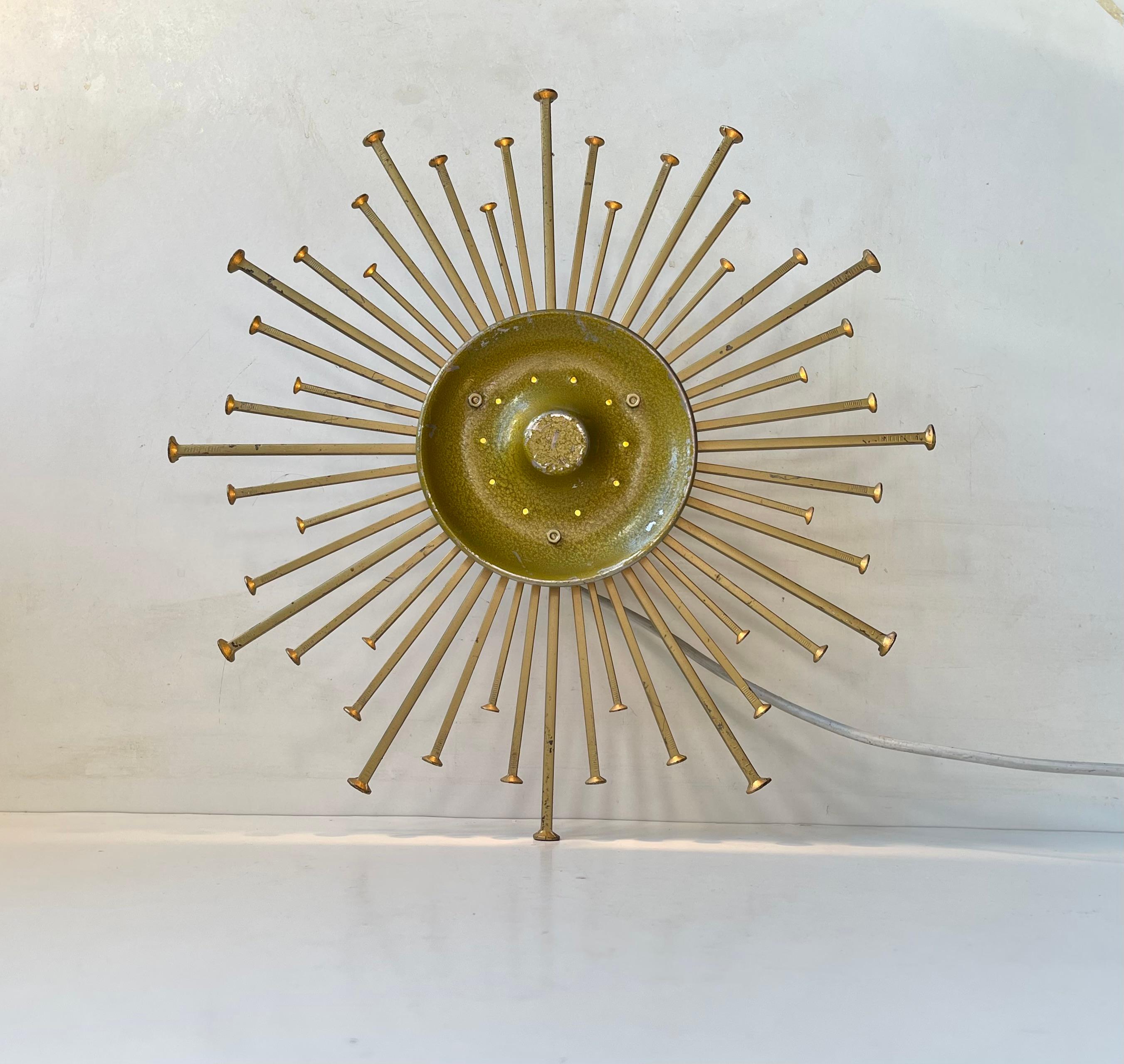 A matching pair of sculptural wall lights depicting a bursting sun or star. Constructed using diffrent sizes large iron nails. Powder-coated gold/yellow. Manufactured and designed in Denmark by Dantoft Metal Art during the 1970s. Very rare to find a