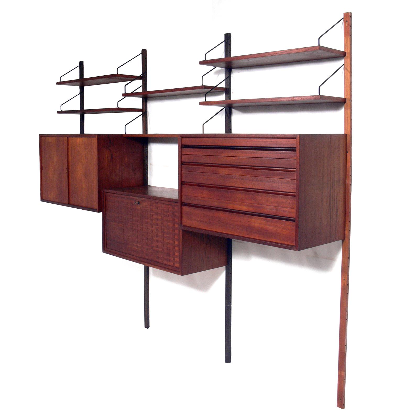 Danish modern wall unit or home office, designed by Poul Cadovius for Cado, Denmark, circa 1960s. This piece is completely adjustable, and any of the case pieces or shelves can be installed anywhere up and down the wall-mounted uprights.
This piece