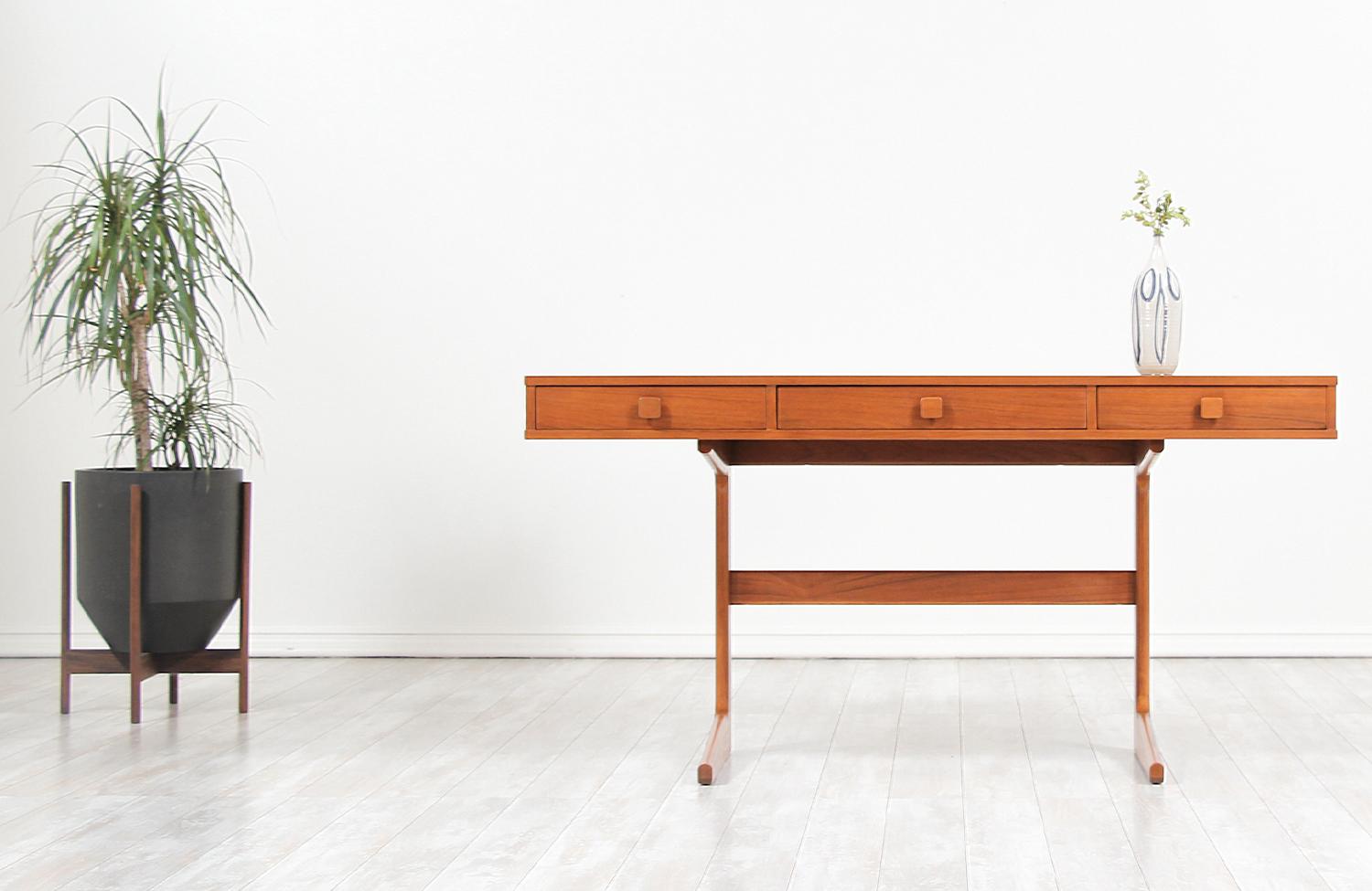 Elegant cantilever desk designed by Georg Petersens for Georg Petersens Møbelfabrik in Denmark, circa 1960s. This unique design features a sturdy desk top that is complemented by three drawers with sculpted squared pulls. The desk appears to be