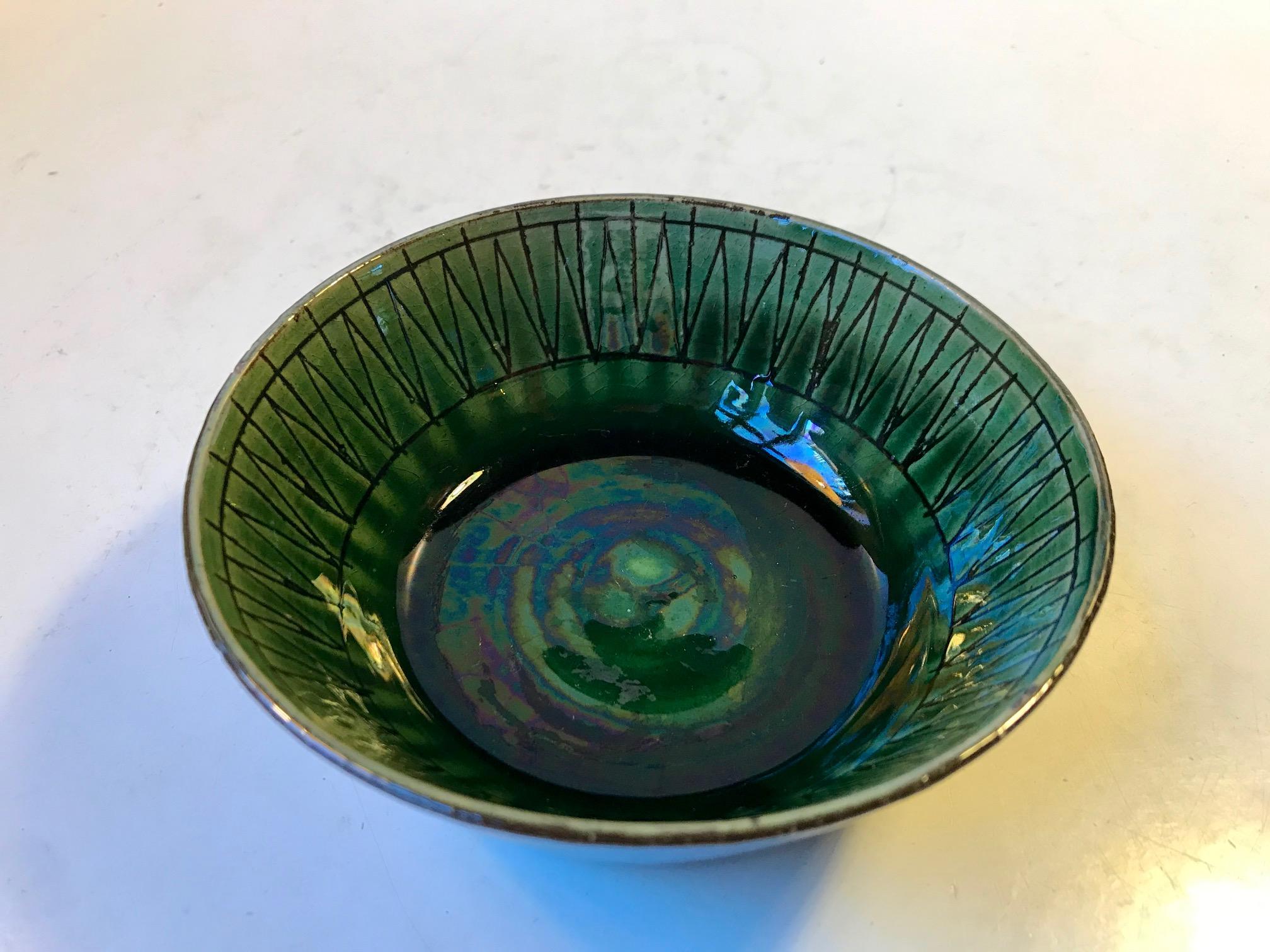 Small ceramic bowl with oily green glaze and geometric arrow incisions. Designed by the Danish ceramist Thomas Toft and manufactured at his own studio during the early 1960s. It is signed to its base.
