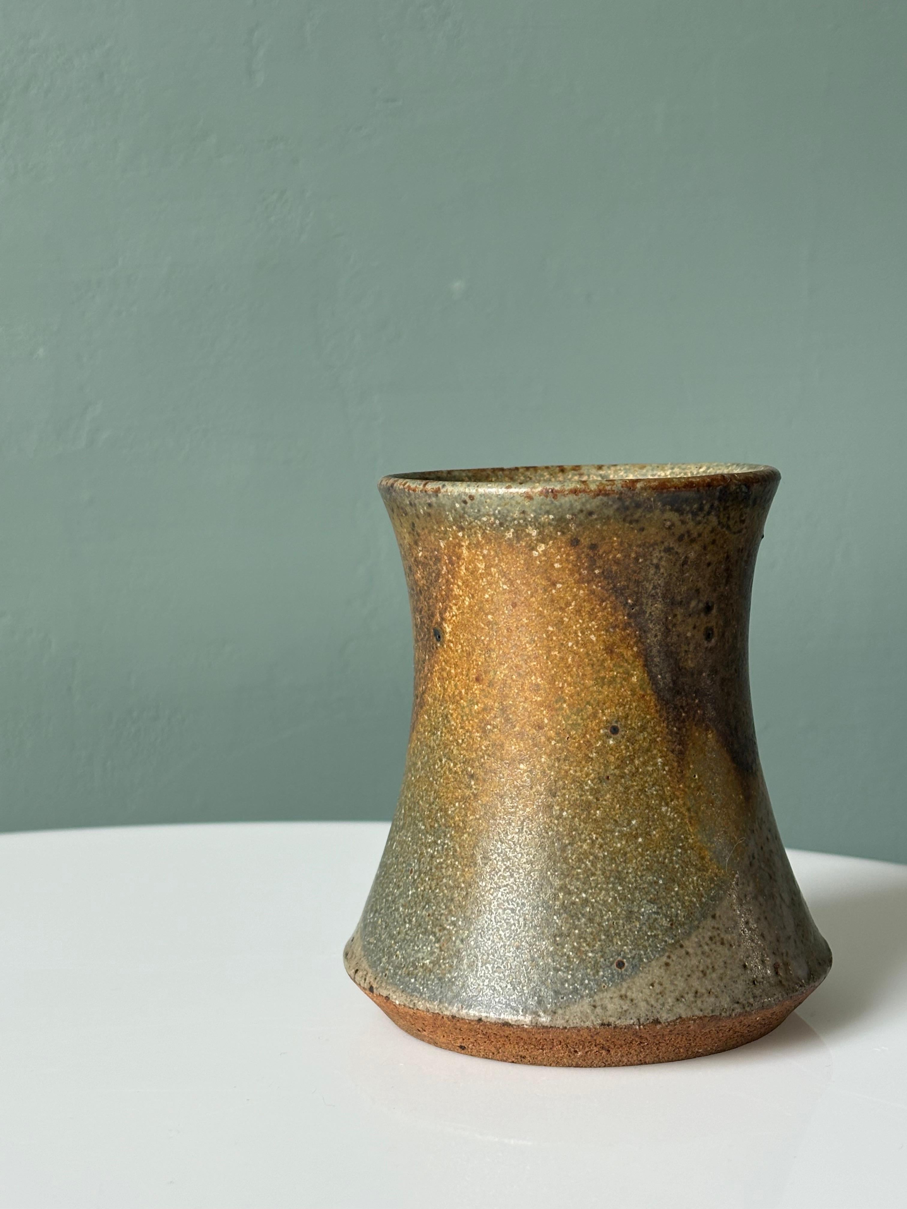 Vaso in ceramica danese della metà del secolo scorso realizzato a ruota. Smalto color terra con linee asimmetriche di colori verde oliva, azzurro e marrone. Base angolata non smaltata con firma.  
Bellissime condizioni vintage. 
Danimarca, anni '60. 