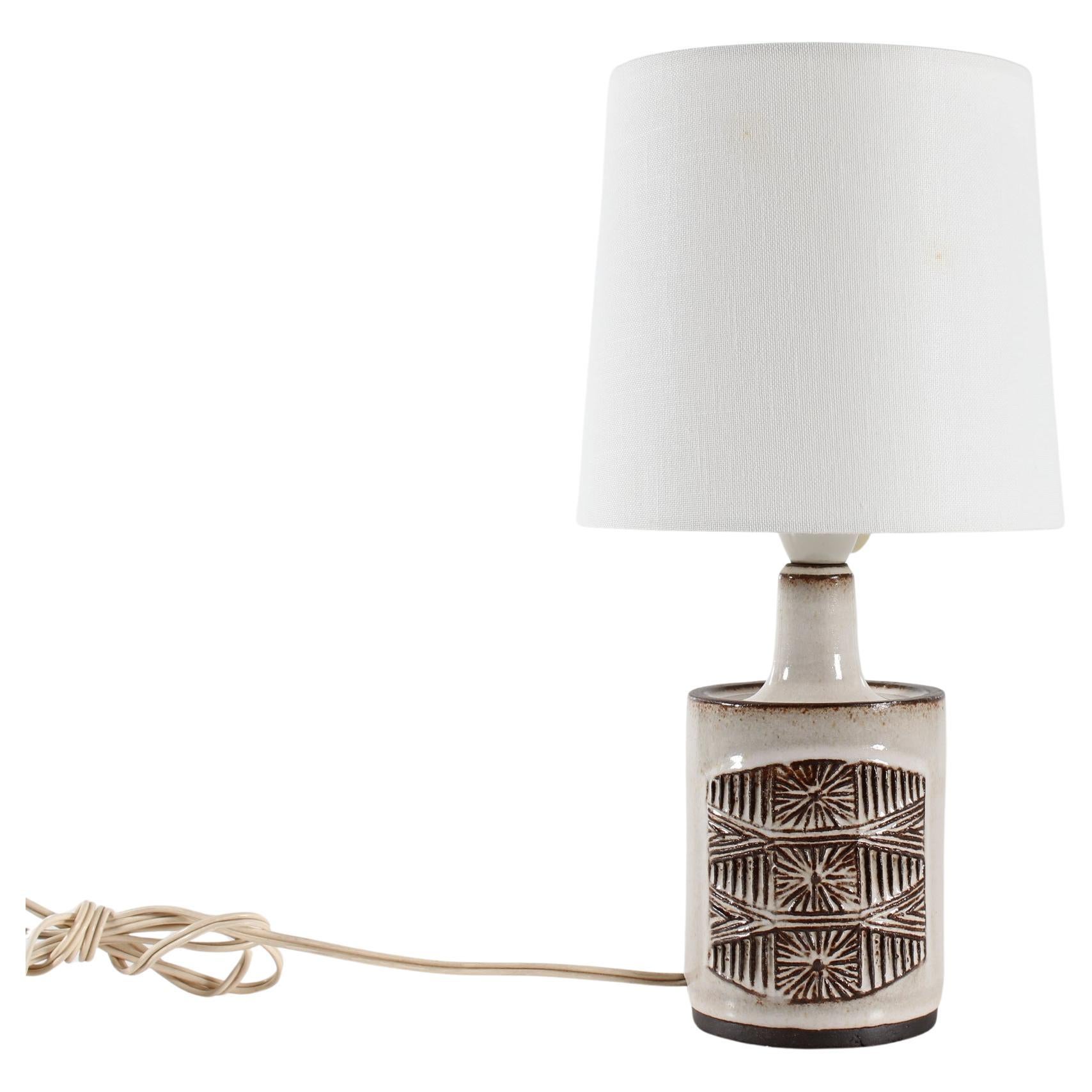 Medium size ceramic table lamp made by the ceramic workshop Stogo in Denmark circa 1960s. 

The lamp base is partly glazed and has a graphic pattern on two sides. The colors are beige and brown.

Included is a new clip on bulb lamp shade designed