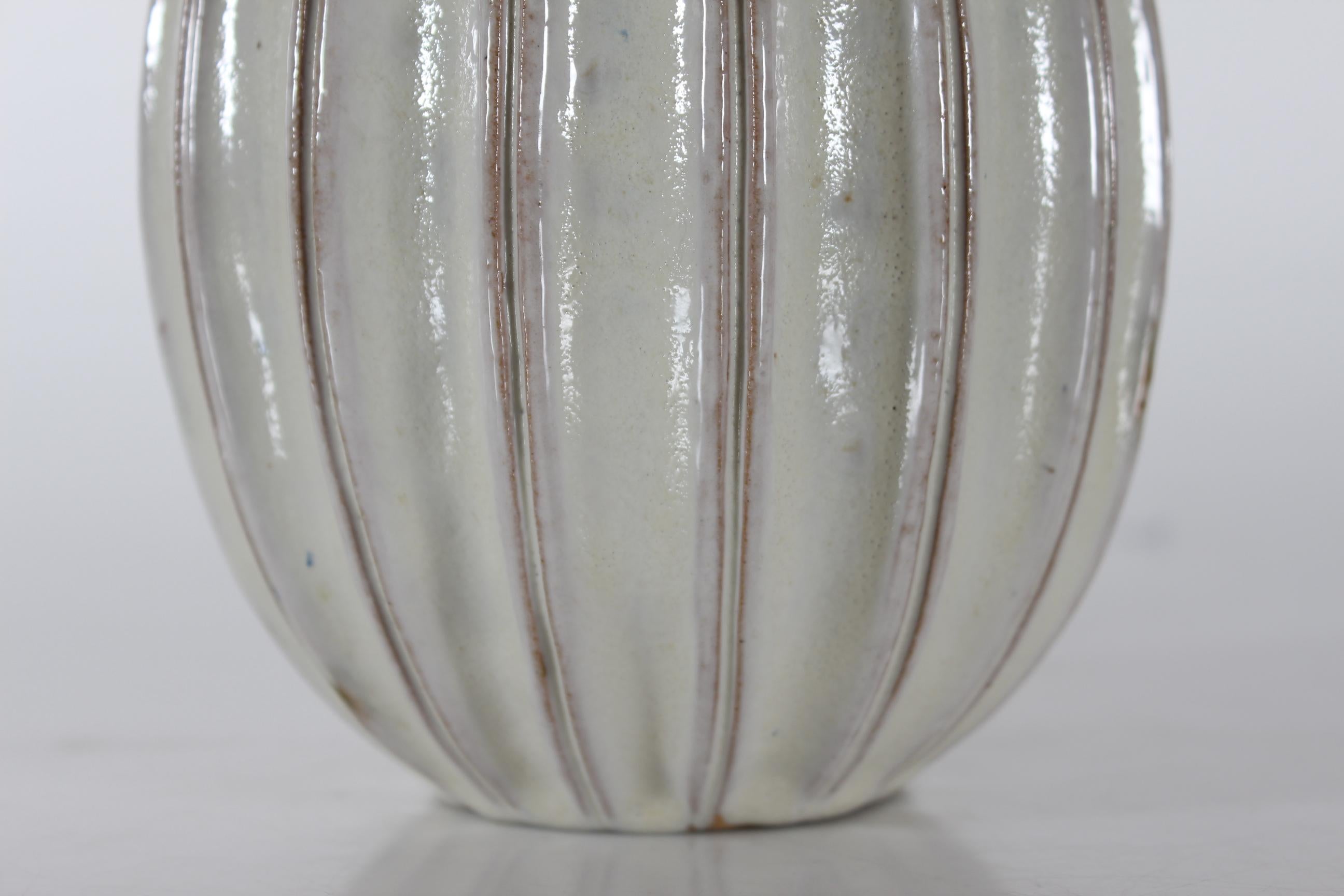 Dänische schlanke, kürbisförmige, geriffelte Tischlampe aus der Mitte des Jahrhunderts von Laurine ceramics in Holbæk, Dänemark. 
Handgefertigt, ca. 1960er Jahre.
Der Lampensockel ist mit einer glänzenden weißen Glasur mit einem zähen