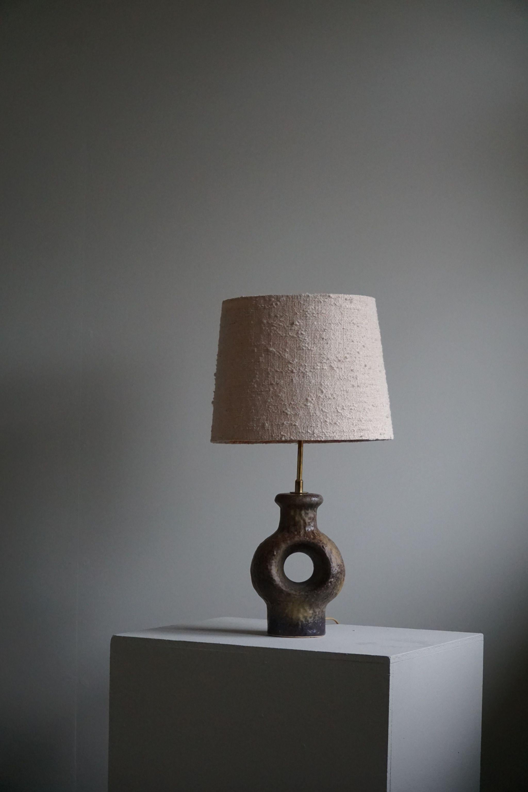 A fine and decorative handmade Danish Mid-Century Modern stoneware table lamp. Various green / brown colors. Unknown artist, made in 1960s. 
A great vintage lamp well suited for the Modern interior or Scandinavian lifestyle.
