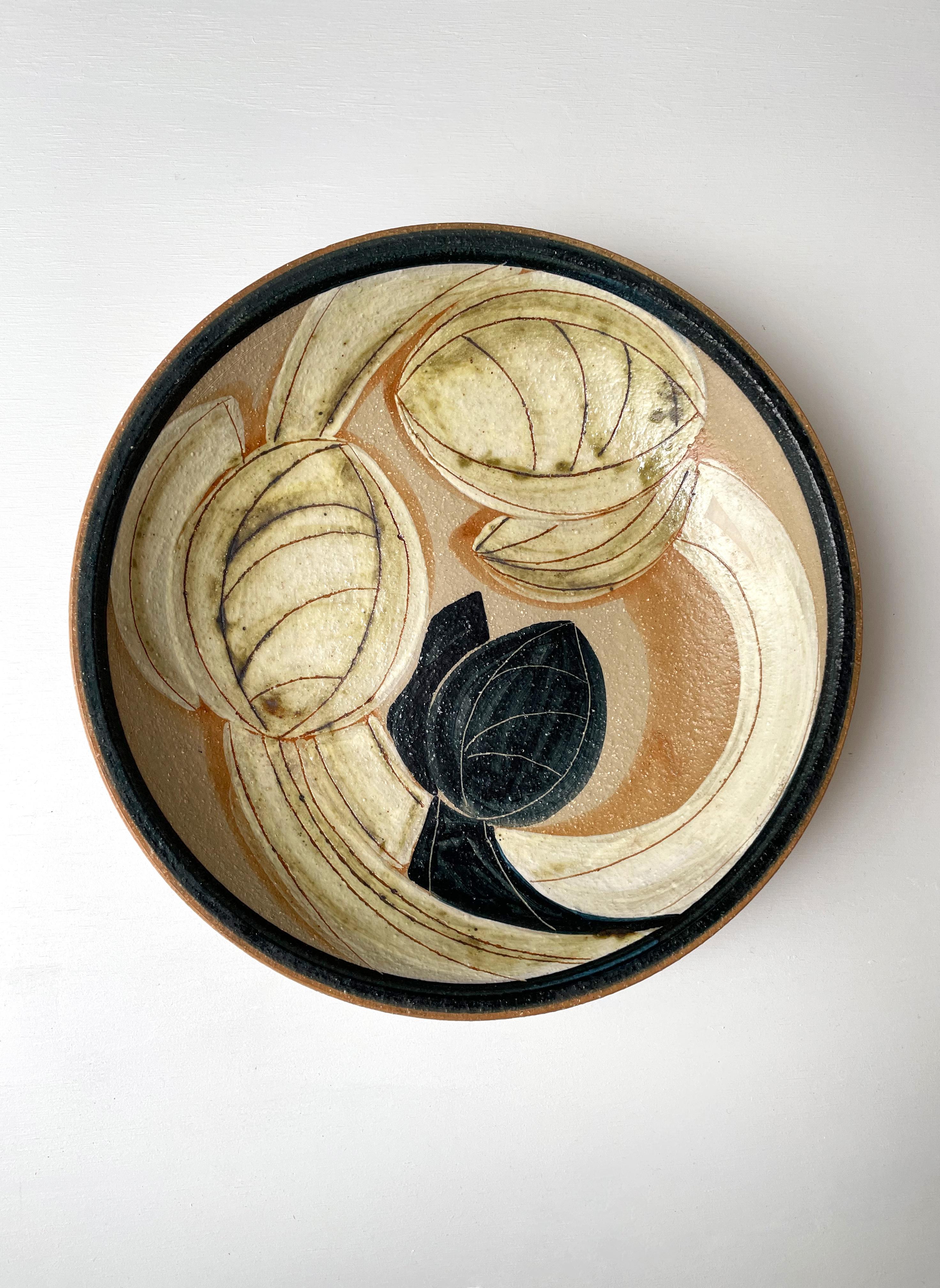 Graphically stunning large modernist handmade wall plate / bowl / centerpiece by ceramic artist Noomi Backhausen. Handpainted stylized organic floral decor in black, creamy yellow, warm orchre and clear glaze with carved lines. Raw stoneware on the