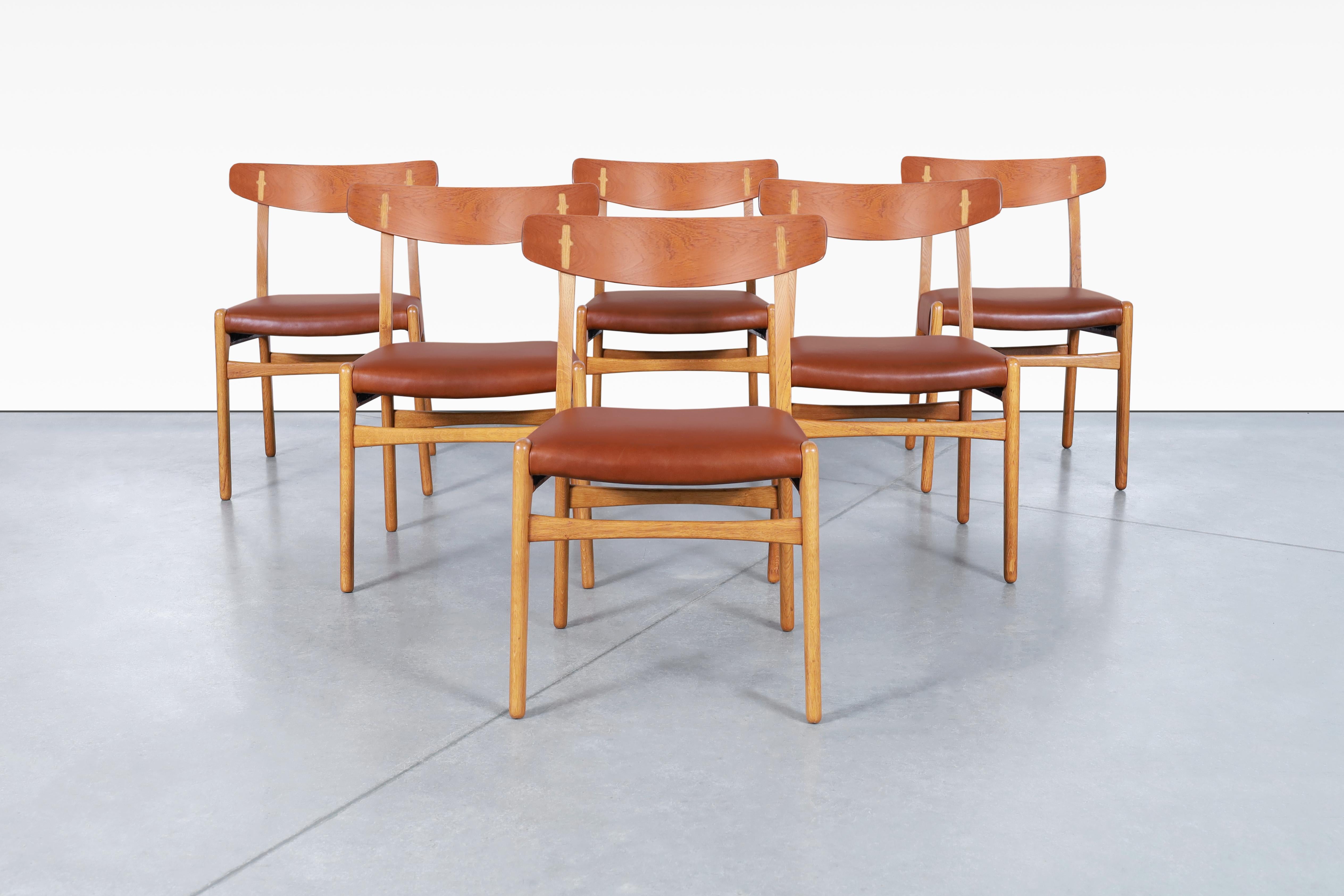 Beautiful Danish modern leather dining chairs designed by the iconic designer Hans J. Wegner for Carl Hansen & Søn in Denmark, circa 1950’s. These famous chairs, also known as CH-23, have been professionally refinished and reupholstered in high