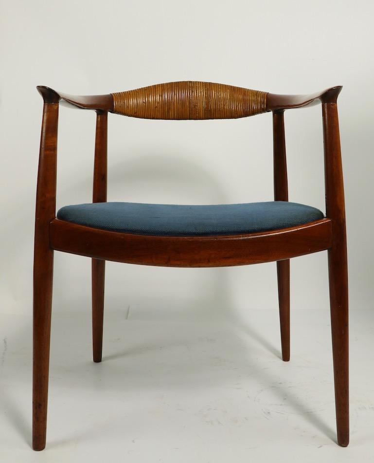 Sleek, sophisticated and architectural, wraparound armchair in solid rosewood, designed by Hans  Wegner  made by Johannes Hansen The chair has a solid rosewood frame, drop in upholstered seat, and wrapped cane backrest. The frame looks like it has a