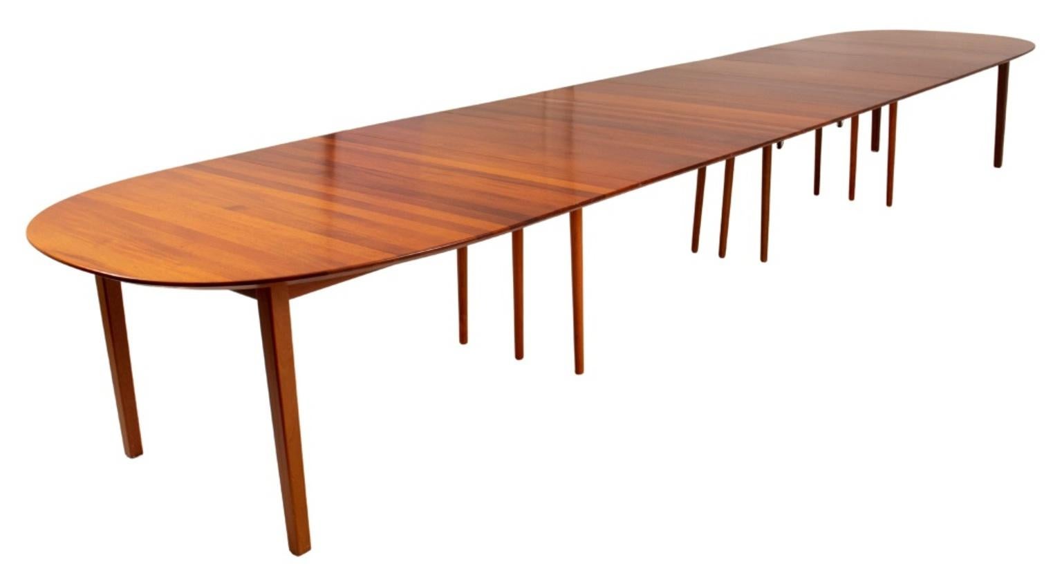 Danish Modern black cherry wood extending dining table, oval above tapering square legs, with eight (8) additional leaves and eighteen (18) tapering columnar support legs, possibly after a model by Ole Hald for Gudme Mobelfabrik, Denmark. 28.5