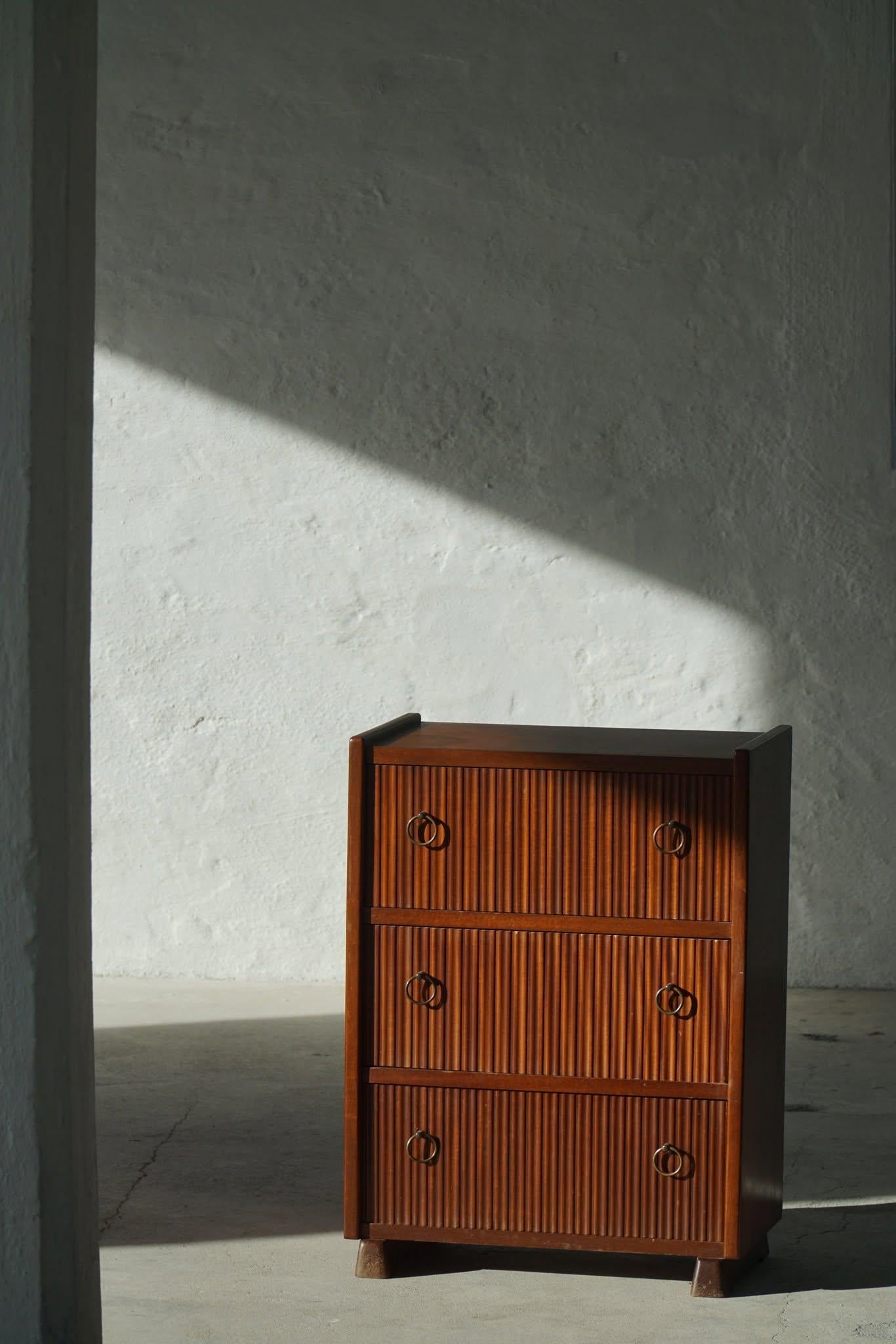 Una cassettiera danese moderna e senza tempo, realizzata in ricco mogano e caratterizzata da linee pulite e proporzioni eleganti. Progettato negli anni '40 e attribuito al famoso ebanista Frits Henningsen, questo pezzo incarna l'artigianato di metà