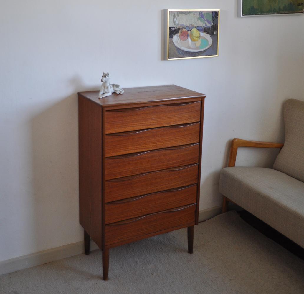 Danish modern chest of drawers in teak veneer with six drawers. The legs are tapered and massive beech. Handles beautiful curved, made in stained beech.

Measures: Height 87.5 cm, width 81.5 cm, depth 44.5 cm 

Condition: Good, signs of wear
