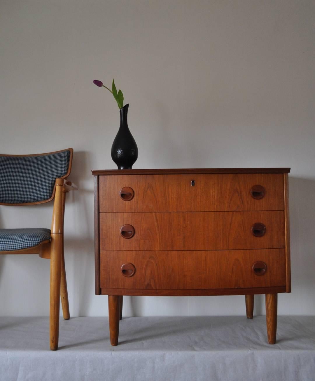 Teak chest of drawers with three drawers. Curved front.
Produced by a Danish furniture maker.

Measures: Height 68.5 cm, width 77.5 cm, depth 44.5 cm.

Condition: good, signs of wear consistent with age and use.  Fine craftsmanship, key incl.