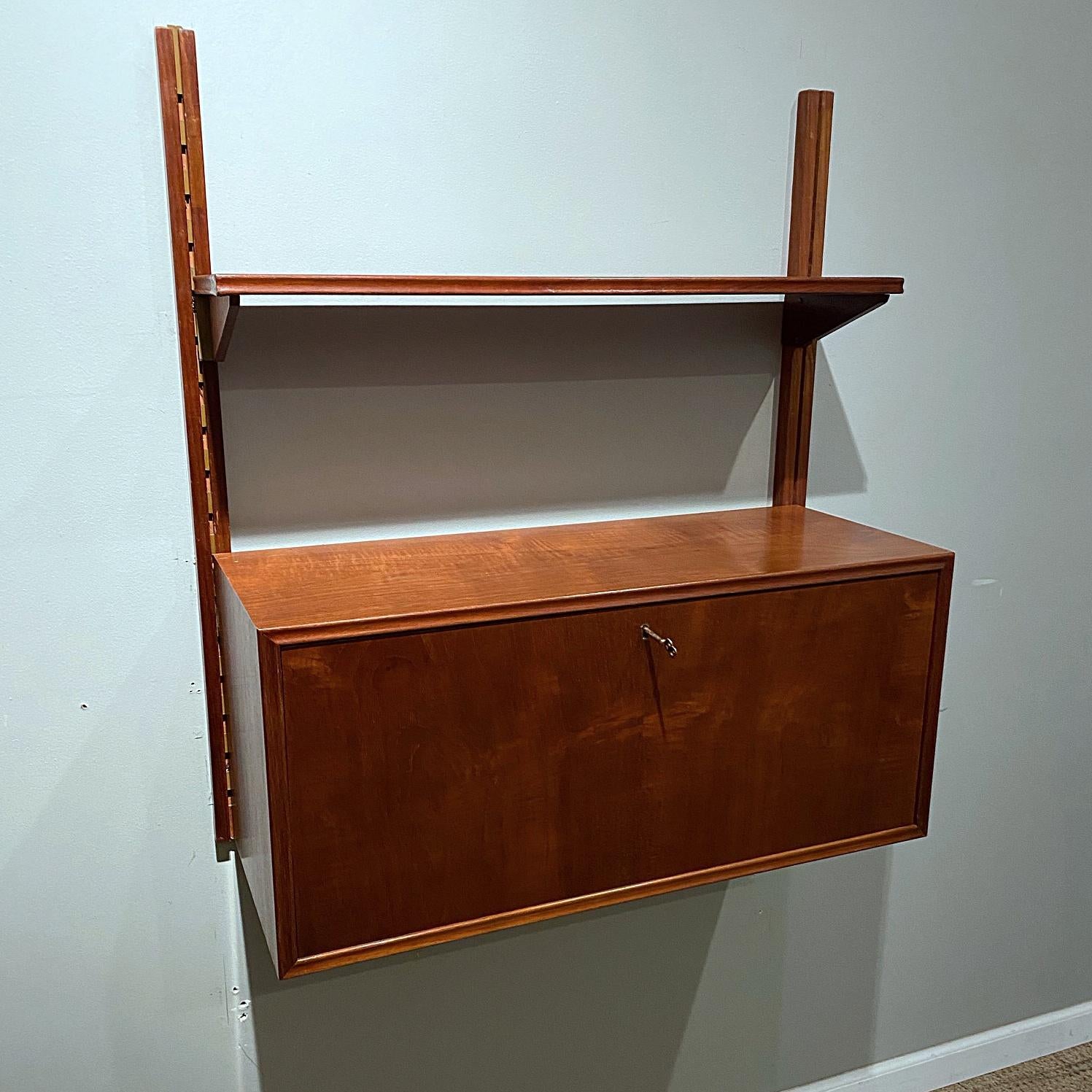 Danish modern child's hanging fall front desk with shelf. Measures: Width- 31 1/2”, depth closed- 12”, depth open- 24”, height- 34 3/4”.