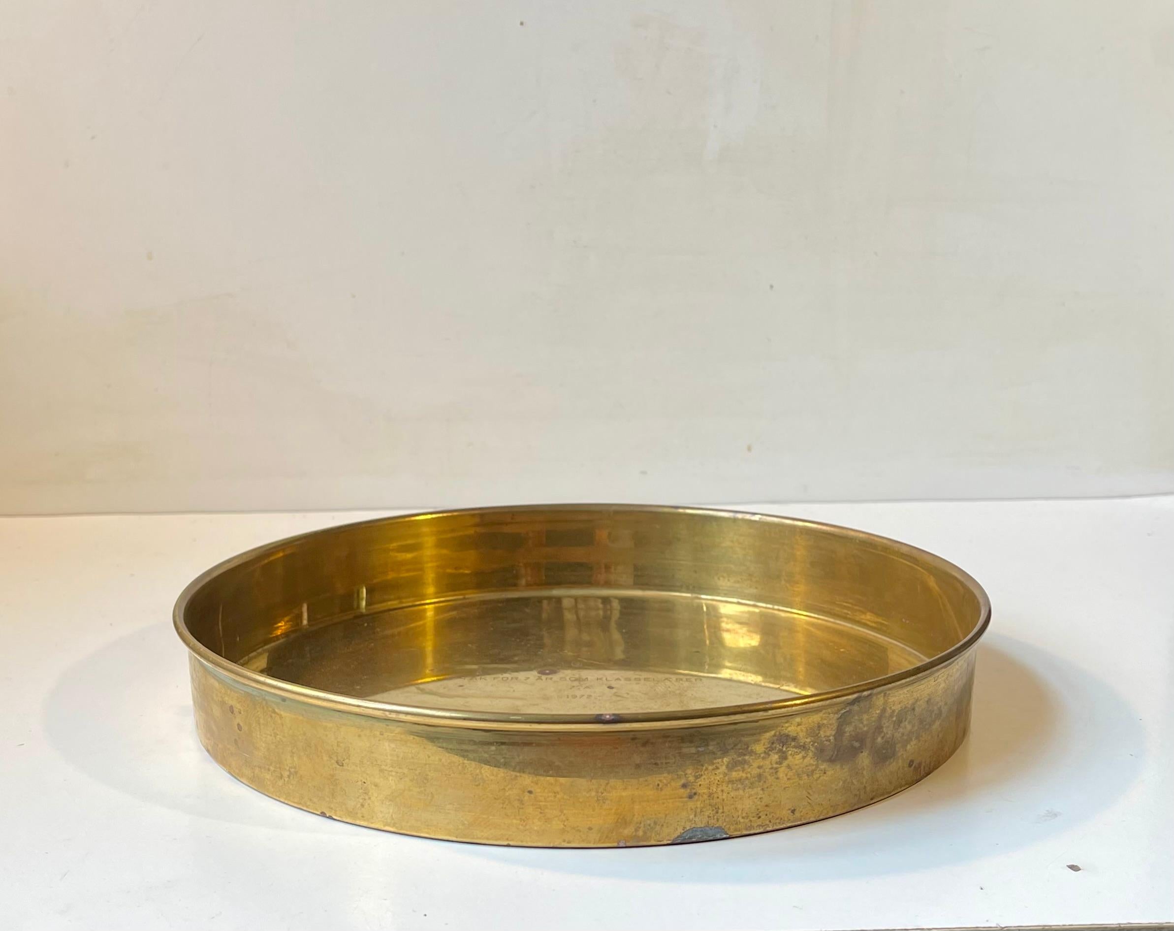 A round brass tray with rolled edge that has developed a rich and raw patina over the years. It was made during the early 1970s by Cawa in Denmark in a style reminiscent of Josef Frank and Stelton. It is suitable for serving drinks or as a 1-2