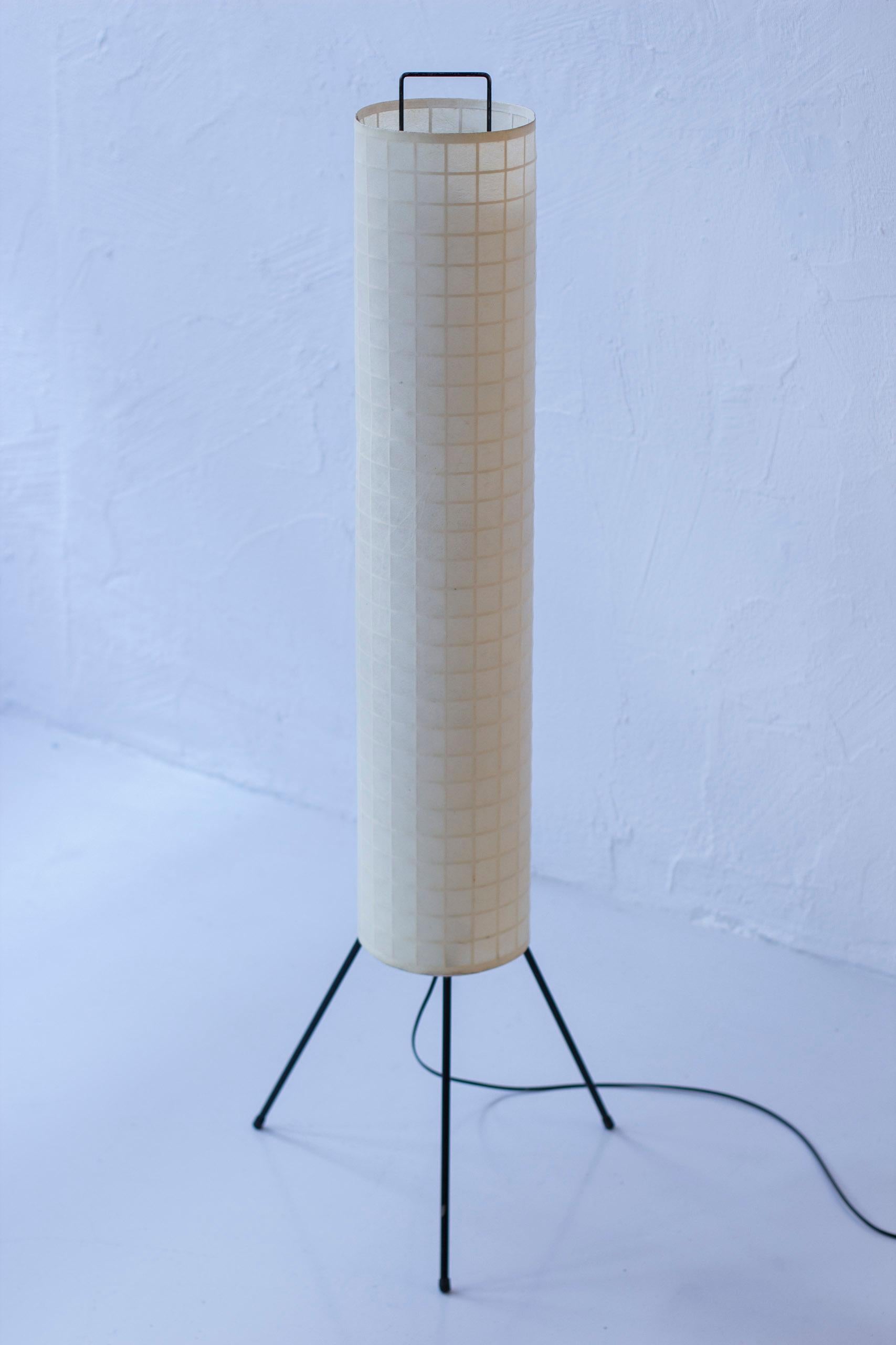 Danish modern floor lamp designed and produced in Denmark. Made sometime during the 1950s. Black lacquered tripod base with a long graphic metal frame covered with cocoon resin weave. Light switch on the chord. Good vintage condition with light age