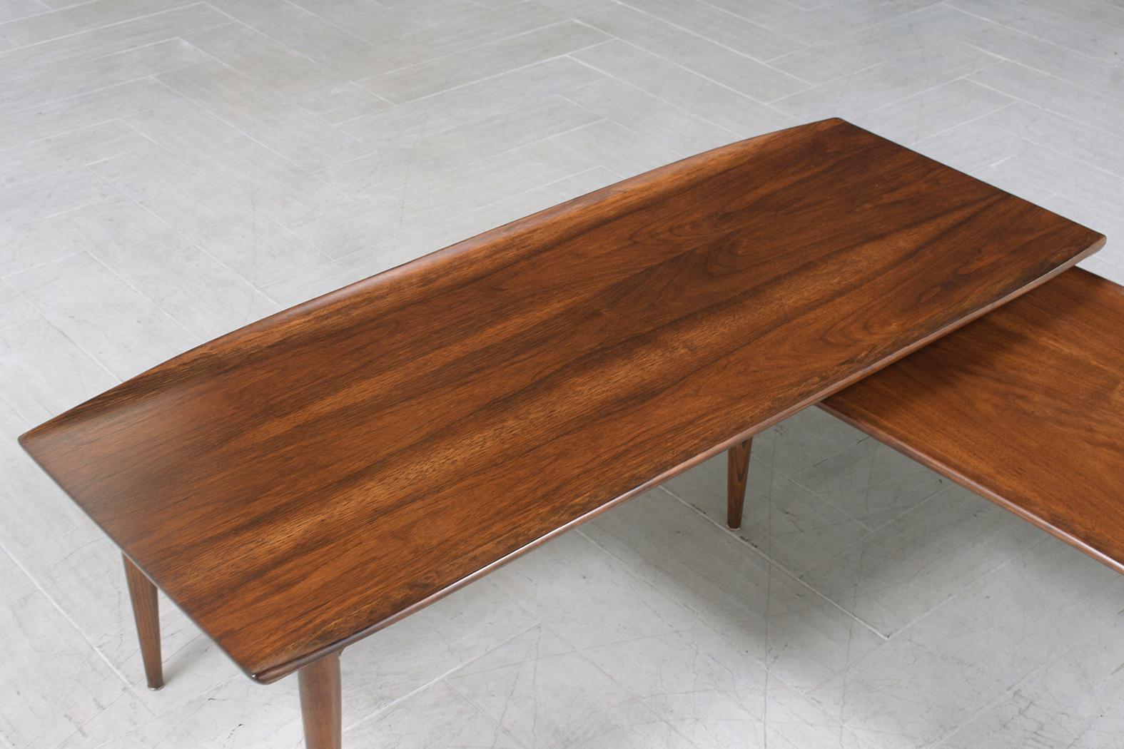 This vintage mid-century modern coffee table is beautifully hand-crafted out of walnut wood and is in great condition and fully restored by our team of expert craftsmen. This coffee table has been completely restored stripped, and refinished by our