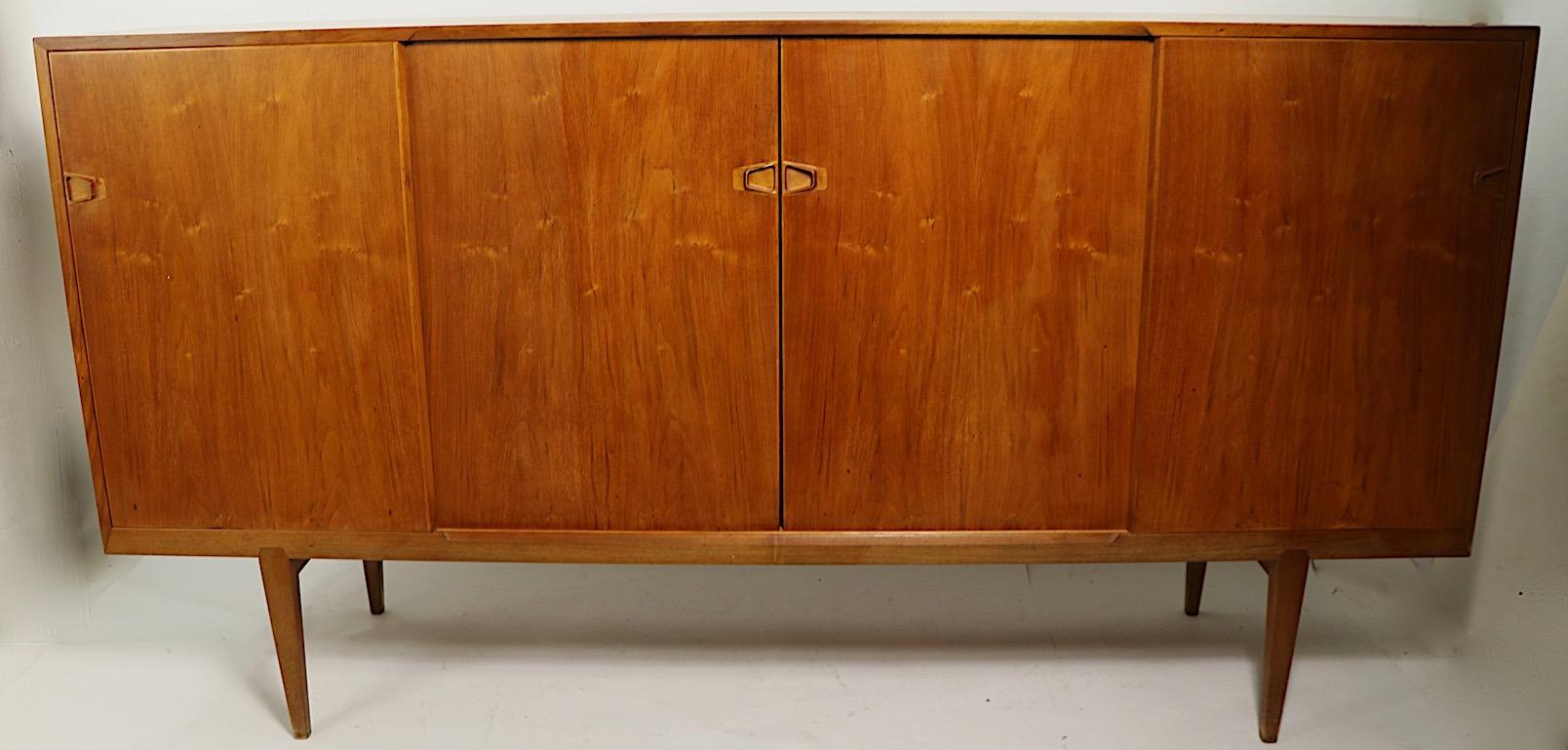 Classic Danish modern sideboard by Brande Mobelindustri for Rosengren Hansen. The credenza features four sliding doors, which open to reveal shelved storage, and interior drawers. This example is in good, original condition, showing only light
