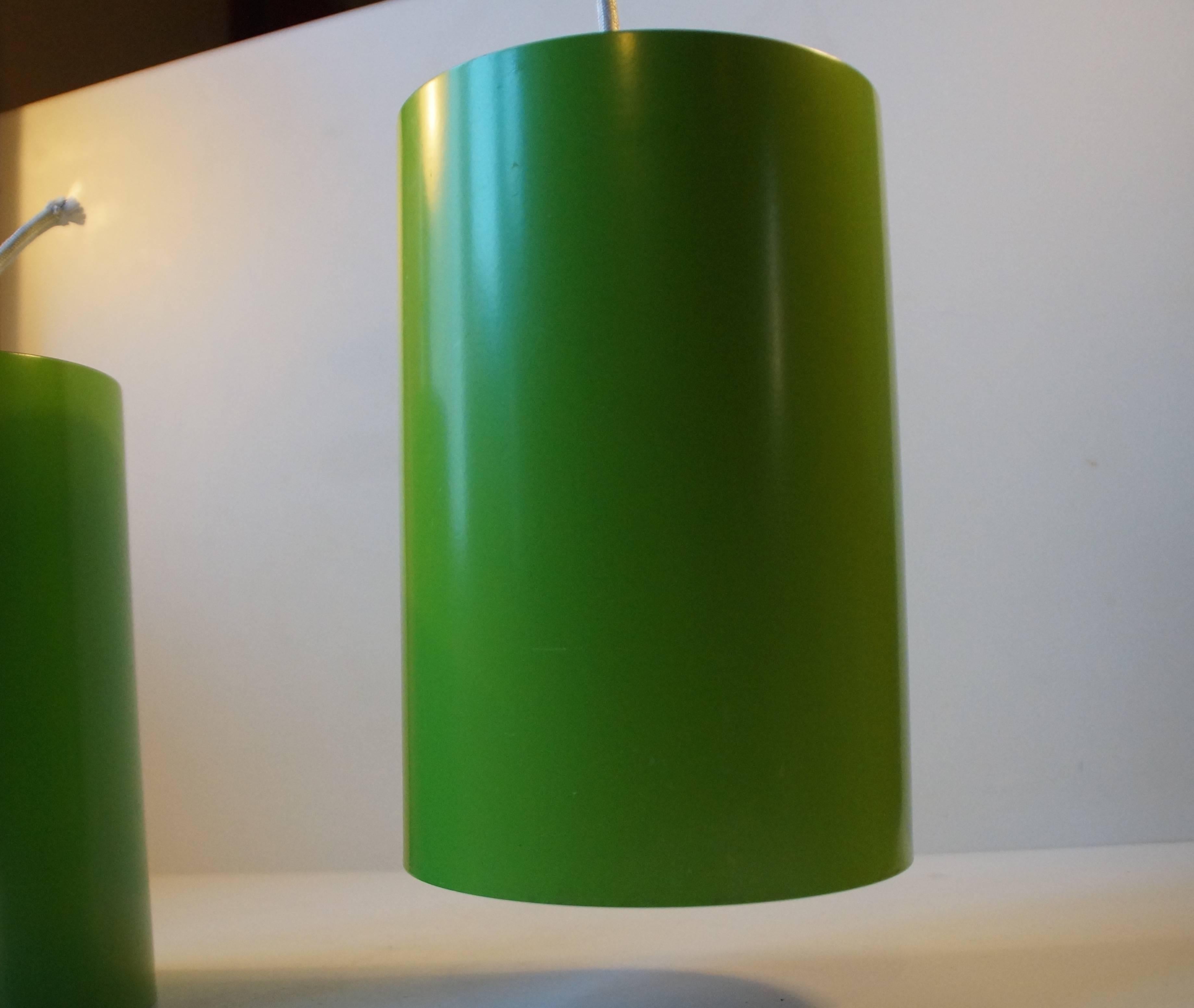 A pair of green pendants designed by Eila and John Meiling and manufactured by Louis Poulsen in the 1970s. Model number: 16512. Both with the old sticker from Louis Poulsen to the inside. Both in nice vintage condition with ware and patina