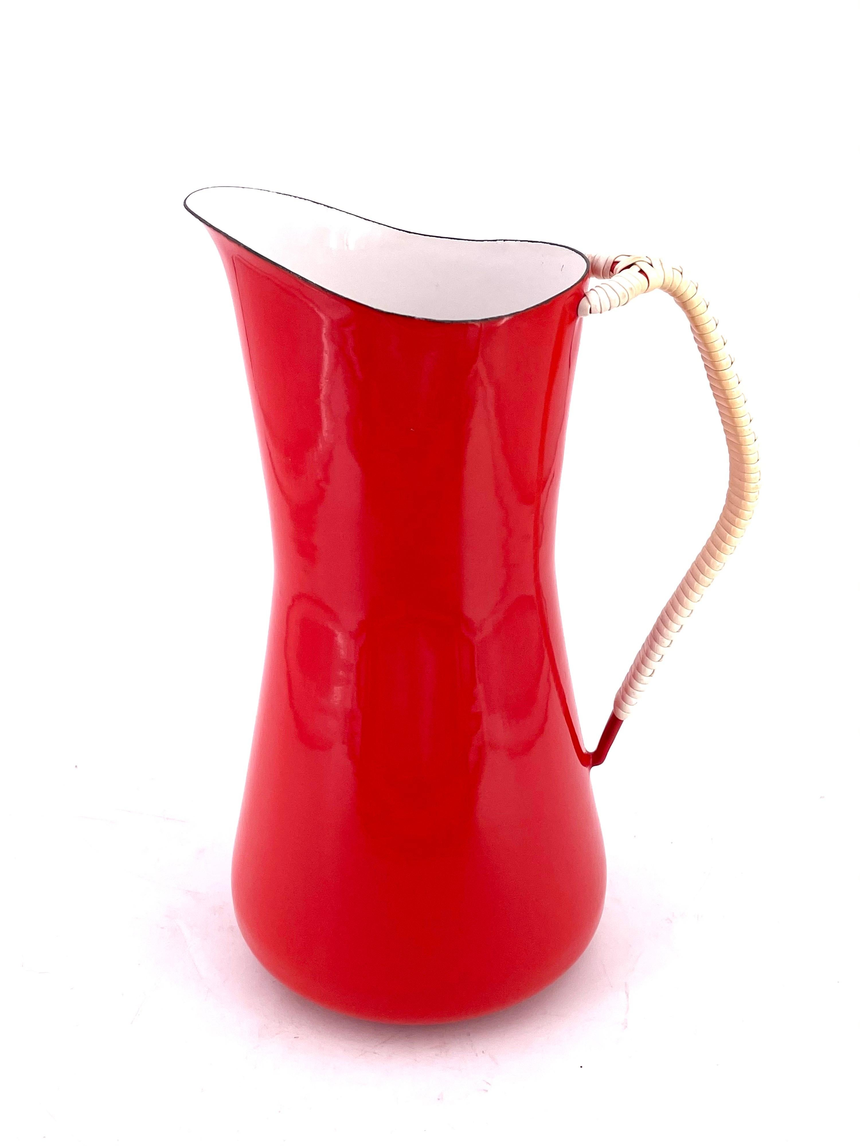 Beautiful, unique, very nice and clean, 1950s water pitcher, in red enameled finish with white interior, good condition. A couple of flea bites on the lower handle as shown, designed by Quistgaard and produced by Dansk.