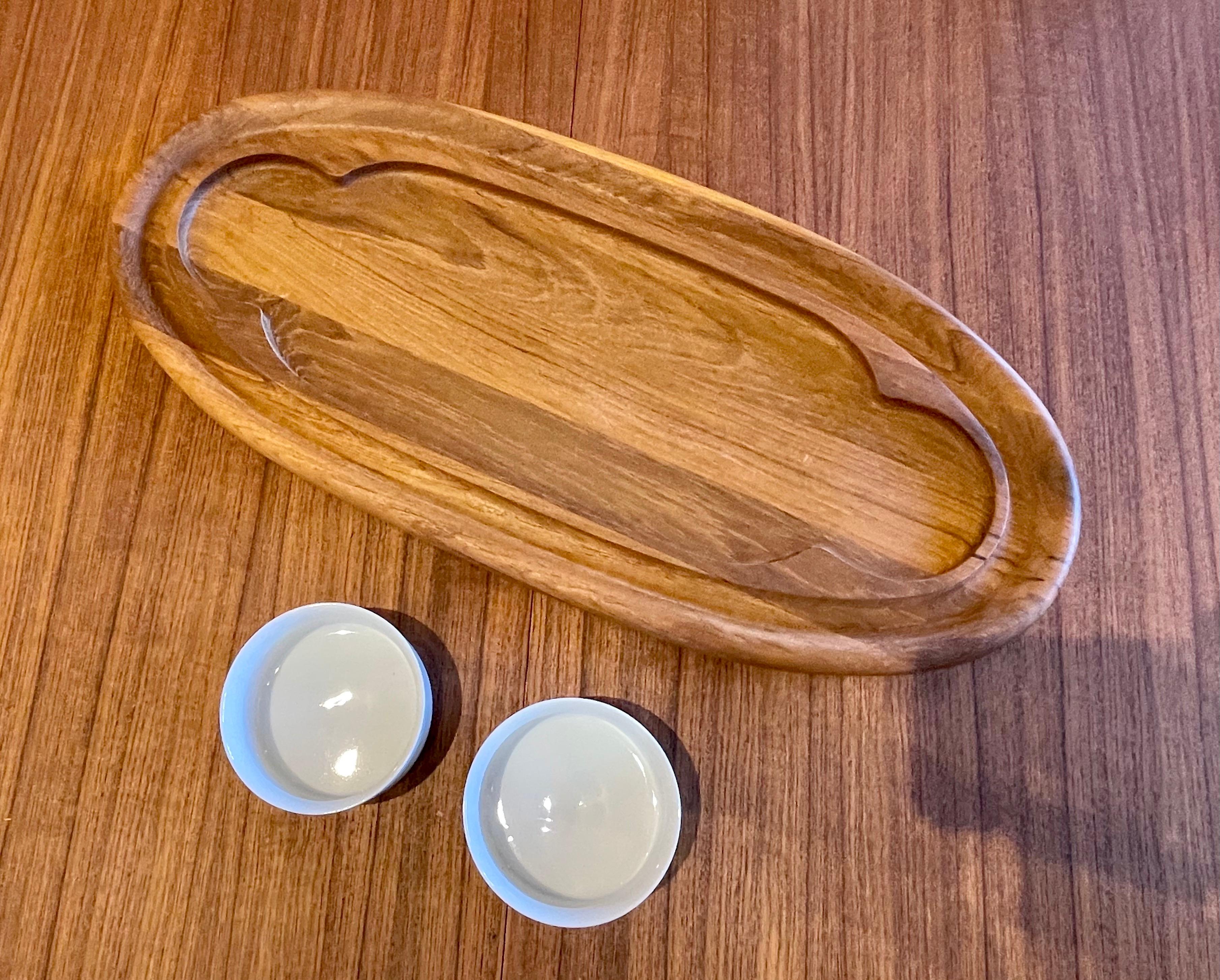 Beautiful oval tray designed by Quistgaard for Dansk in solid teak with porcelain white bowls, circa 1970s, great condition looks like new. Each cup is 4