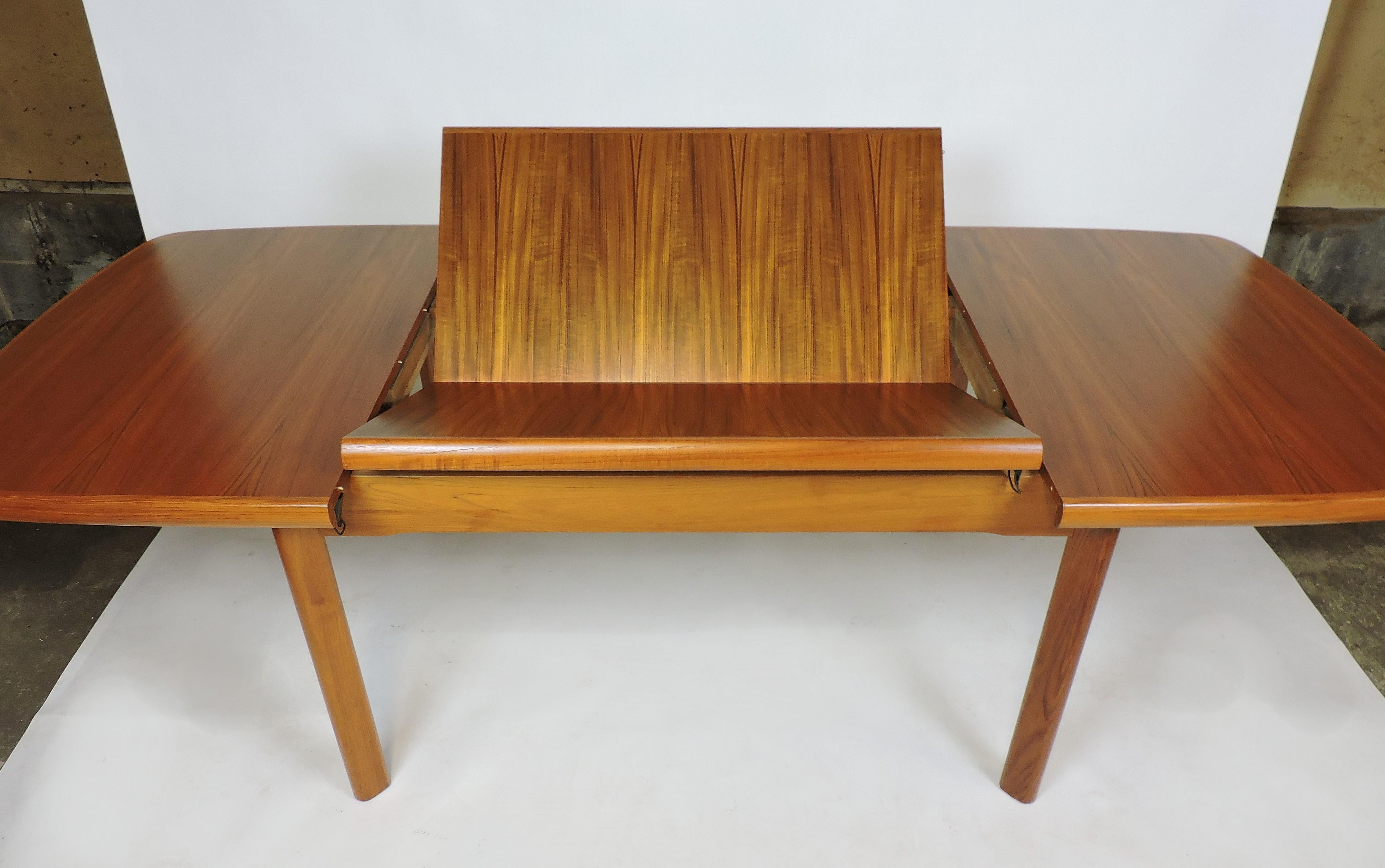 Beautiful and high quality Danish design teak dining table. This table has a self-storing butterfly leaf and can extend from 55 inches when closed to 92 1/2 inches long when opened. The top has a beautiful grain pattern, thick edge banding with