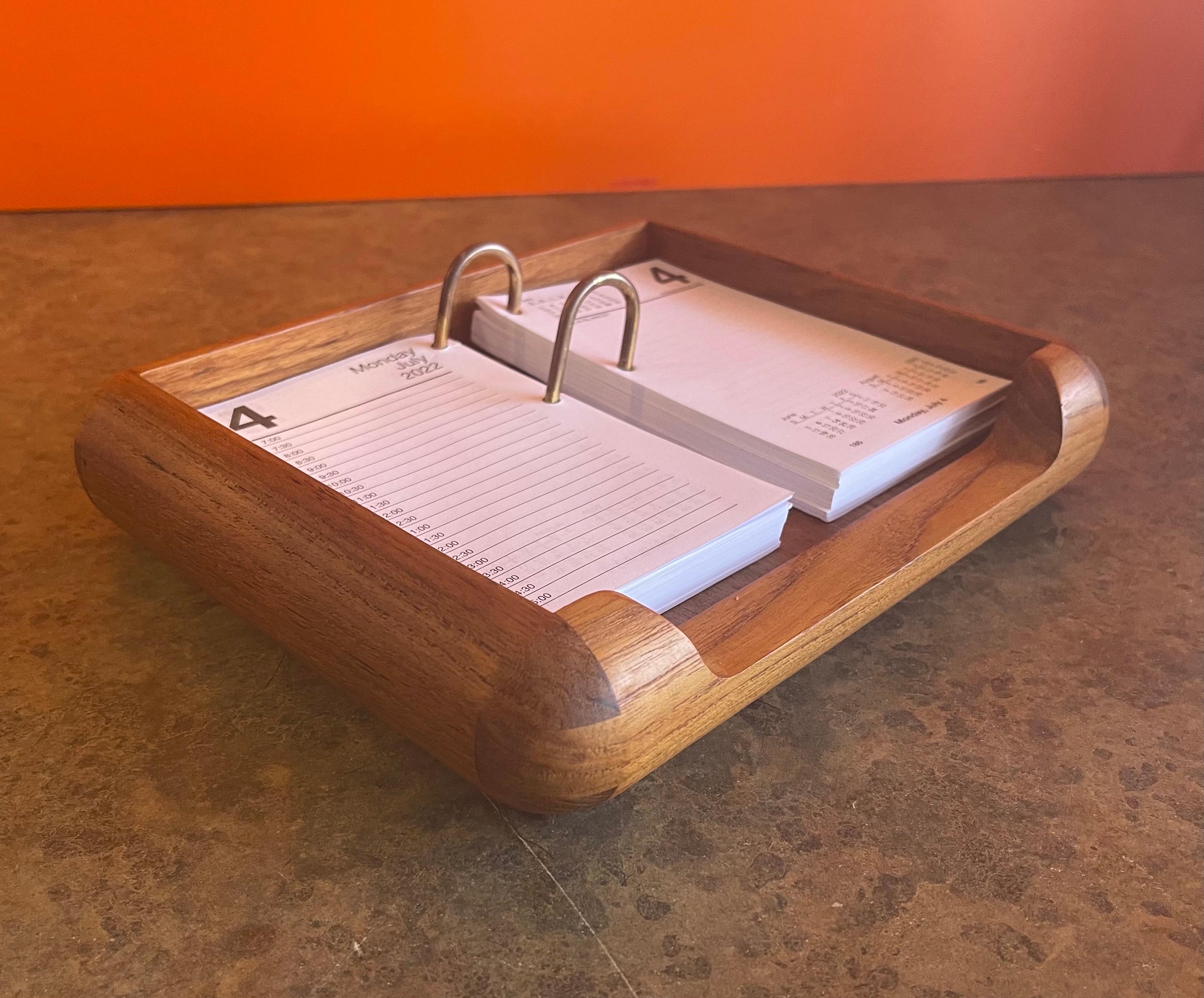 Very functional Danish modern desk loose leaf with 2022 calendar insert in teak, circa 1970s. The piece is in excellent condition and measures 9.25