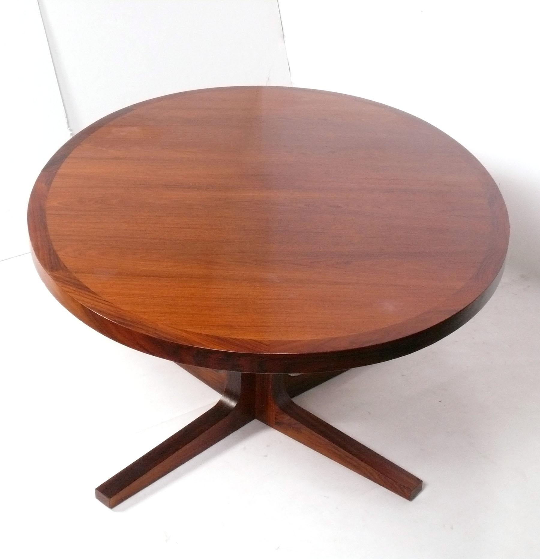 Table de salle à manger danoise, fabriquée par Dyrlund, Danemark, vers les années 1960. Le plateau de la table de salle à manger sera retouché pour mieux s'harmoniser avec les feuilles et la base avant que la table ne soit expédiée. Nous ne savons