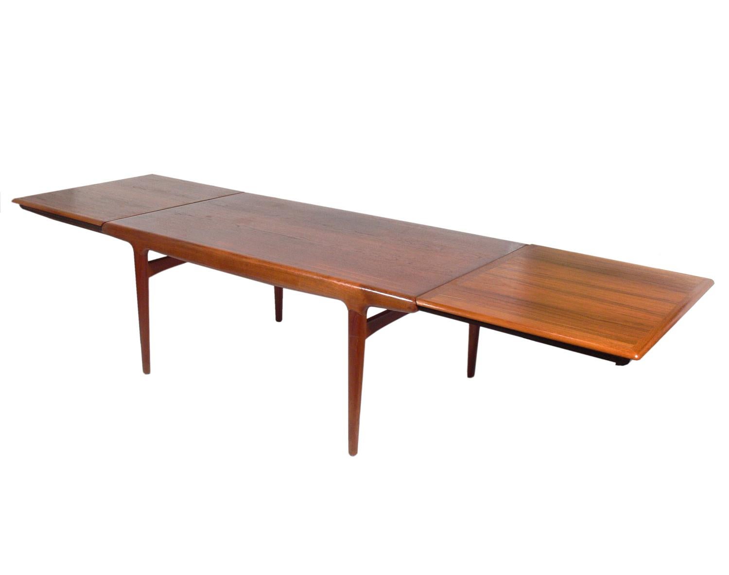 Danish Modern Dining Table in Beautifully Grained Teak, designed by Johannes Andersen, Denmark, circa 1960s. The table expands from 70