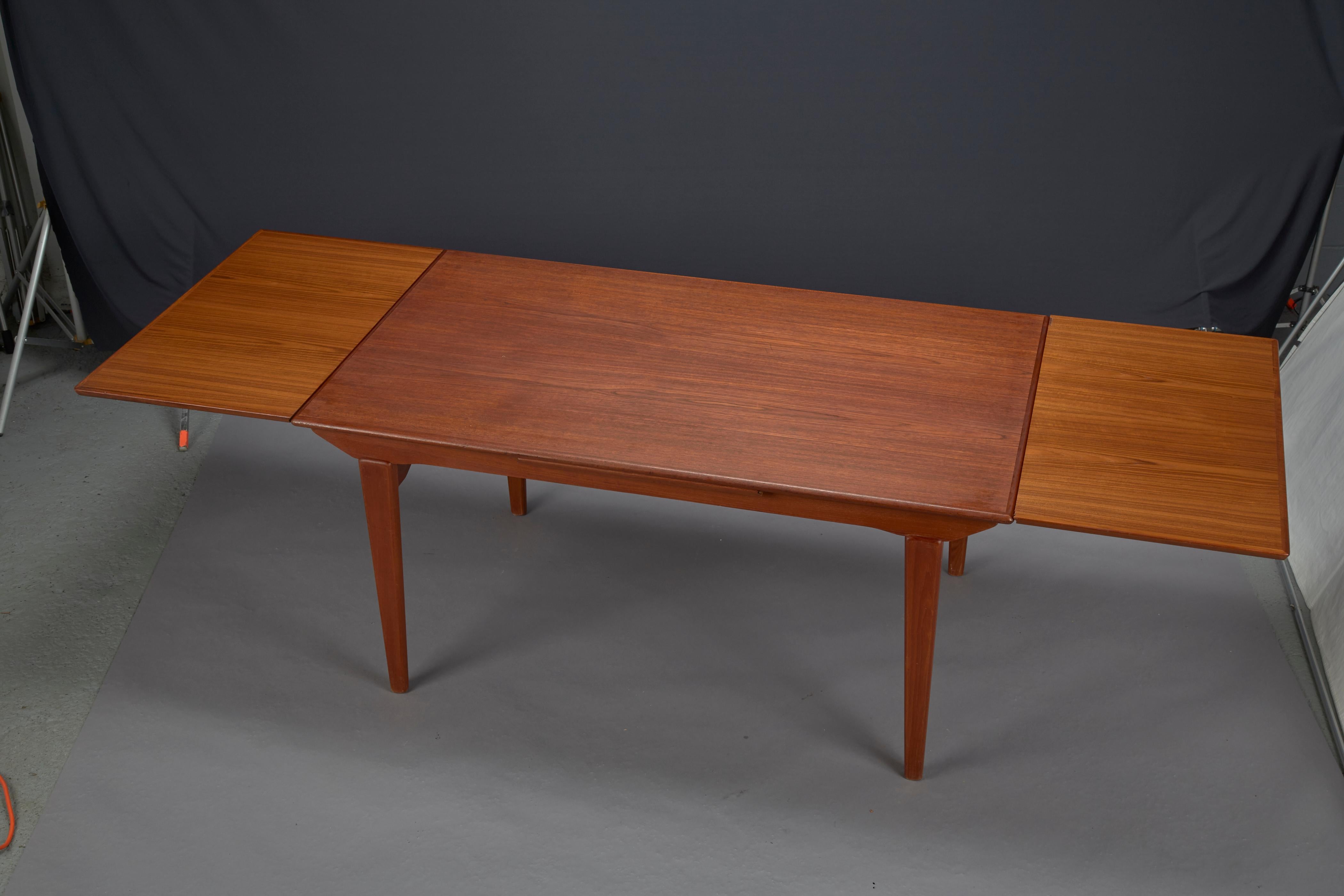 Danish modern teak dining table with two pull-out leaves.
2-19.5